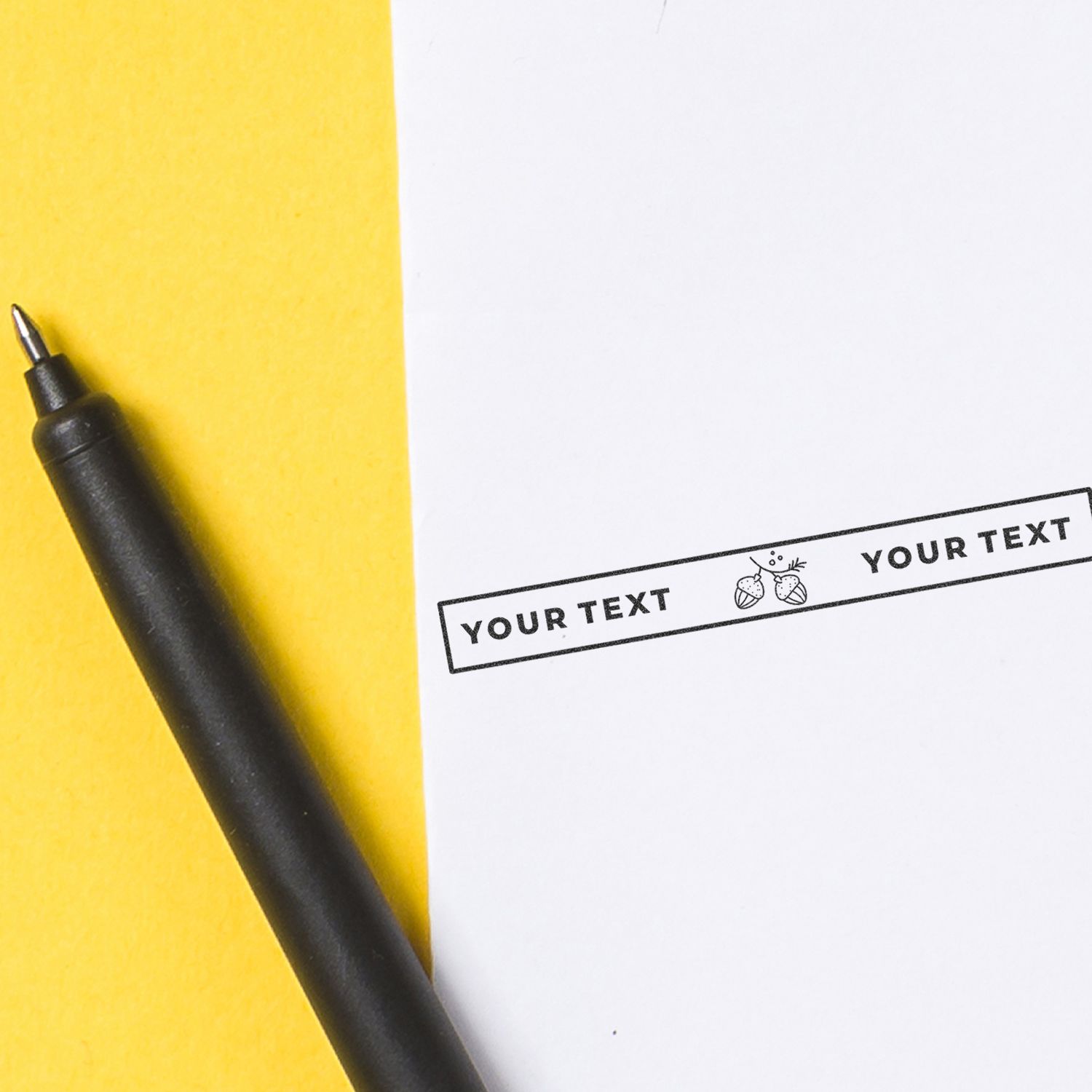 Black pen beside customizable stamp reading YOUR TEXT on yellow and white background for print design
