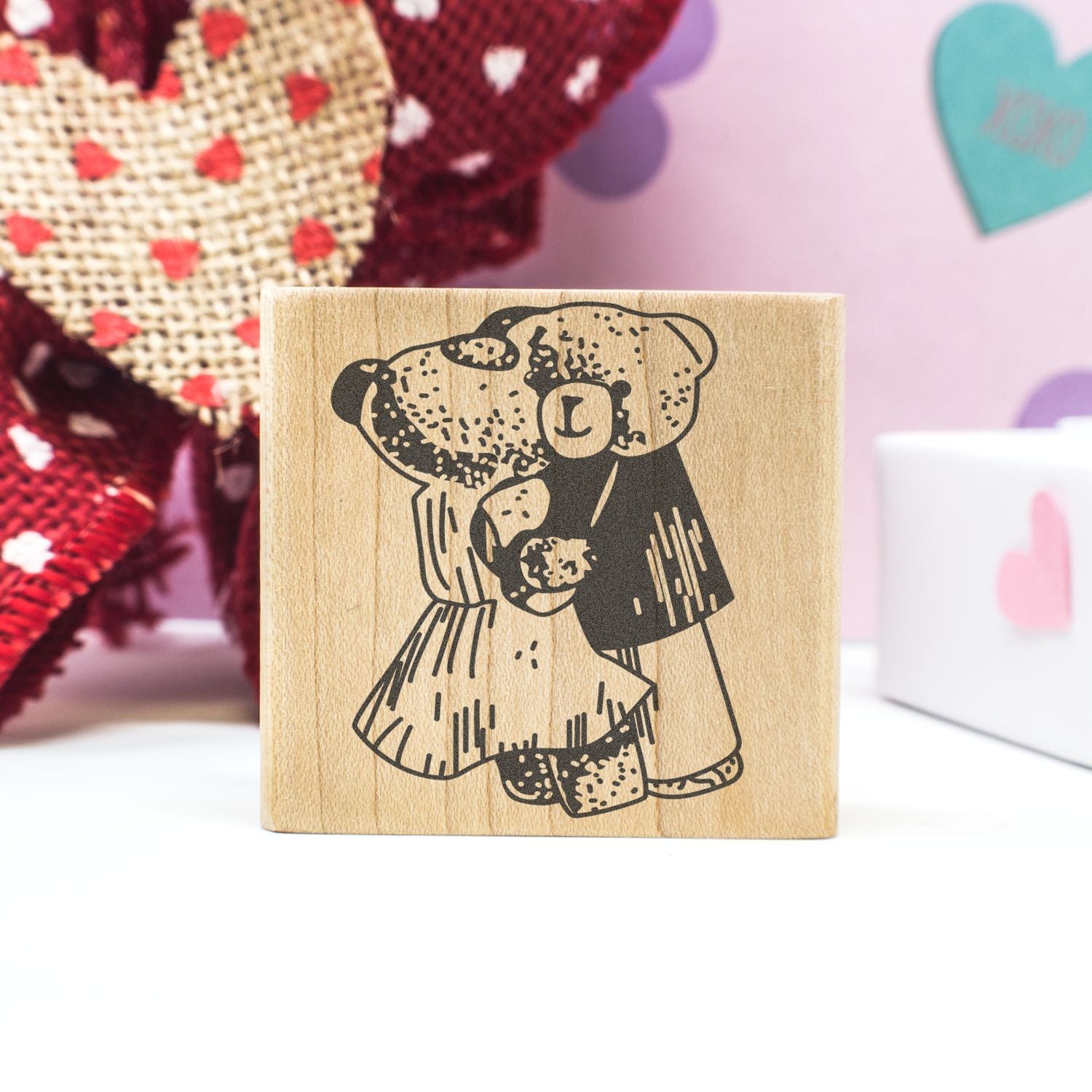 Wooden teddy bear stamp with cute Valentines Day design on a craft table background