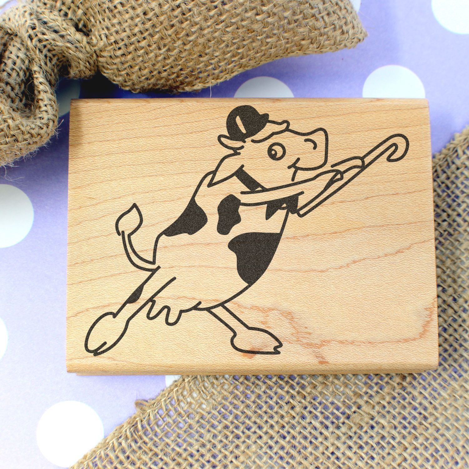 Laser engraved wooden cow sign with a cowboy hat and umbrella, rustic farm decor on a burlap background.