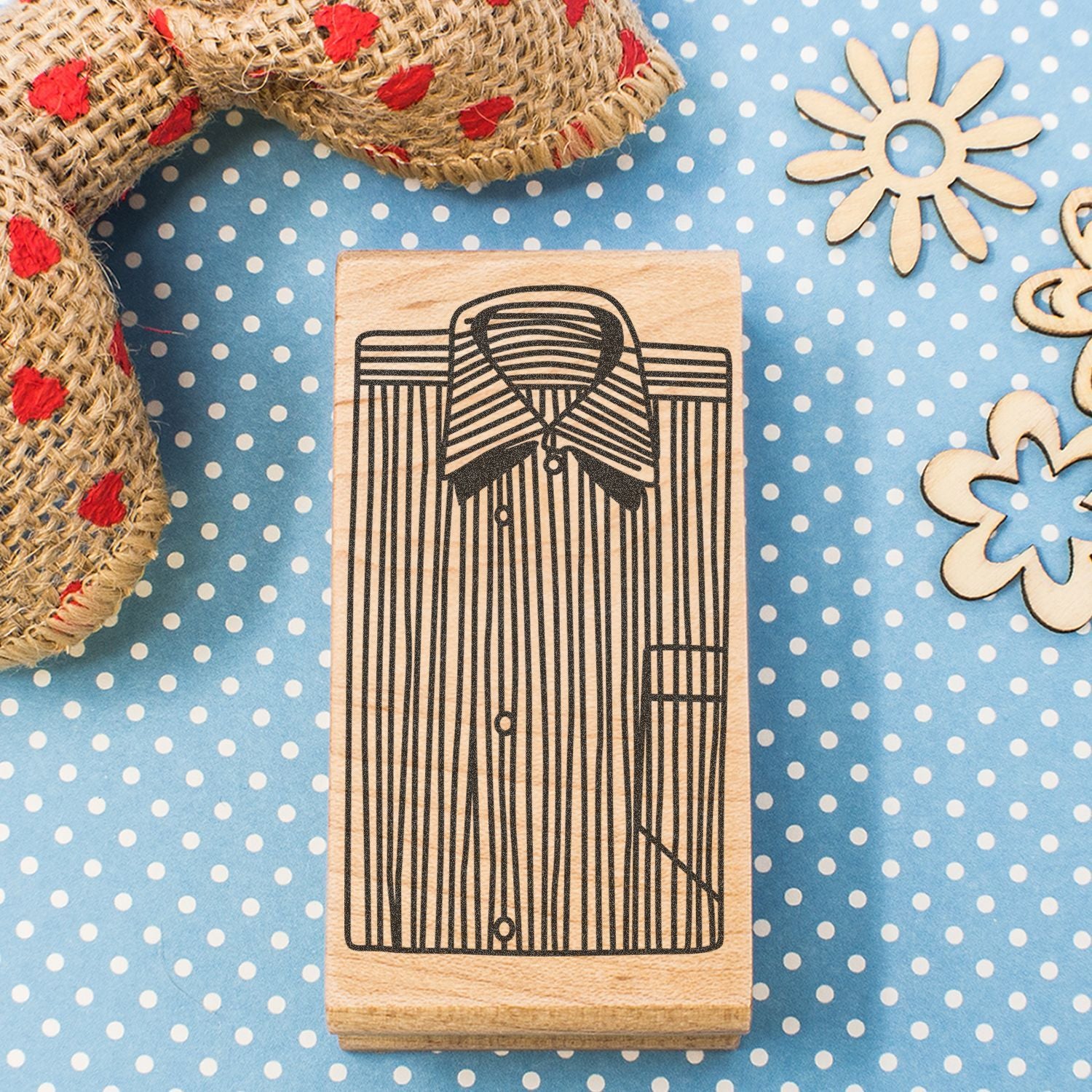 Wooden stamp with tuxedo shirt and bow tie design on blue polka dot craft background.