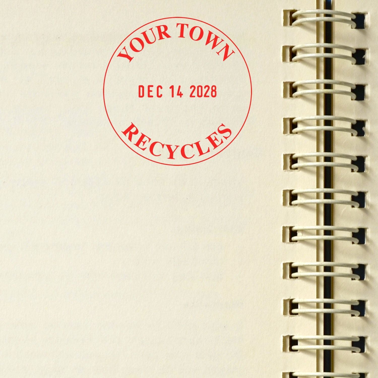 Close-up of a spiral notebook page with a red YOUR TOWN RECYCLES date stamp reading Dec 14, 2028.