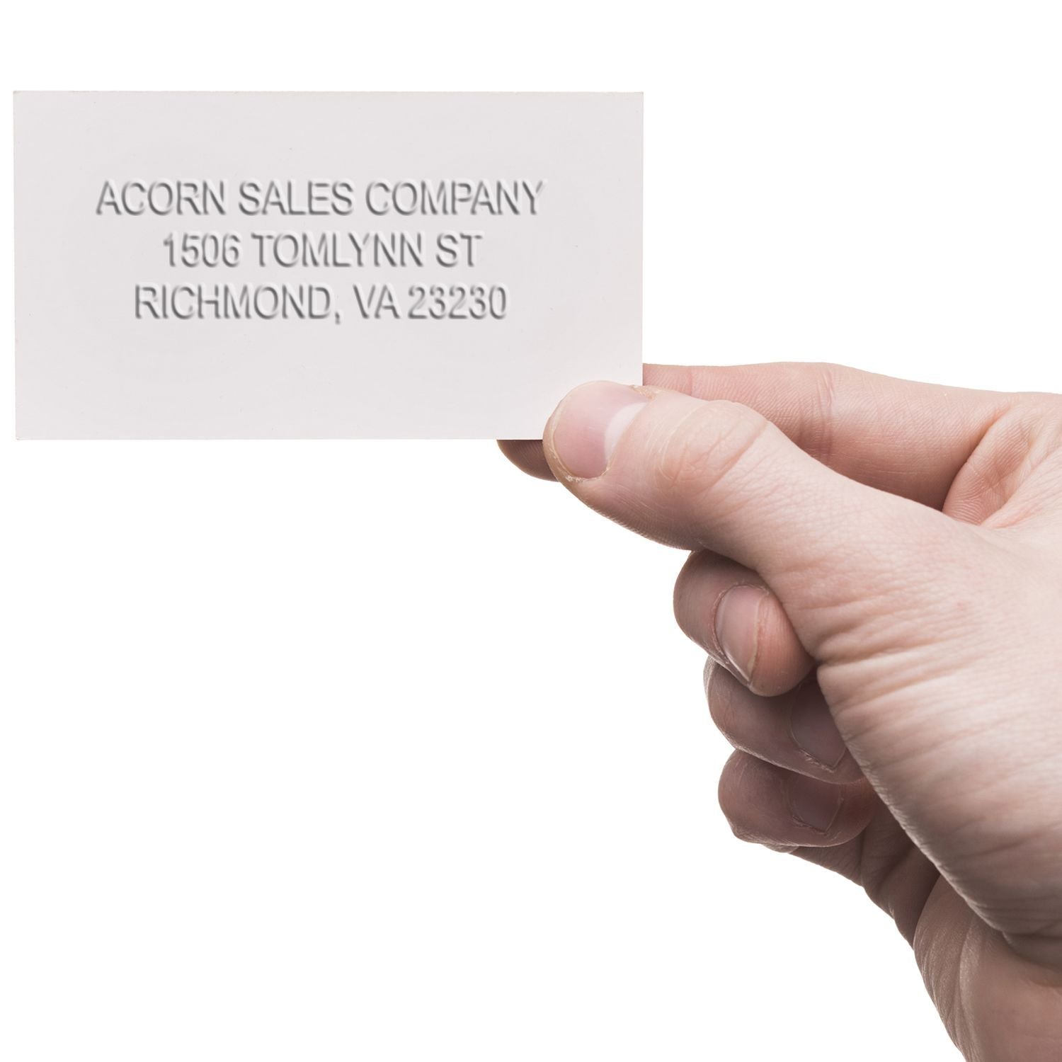 Hand holding a white Acorn Sales Company business card with embossed address in Richmond, VA.