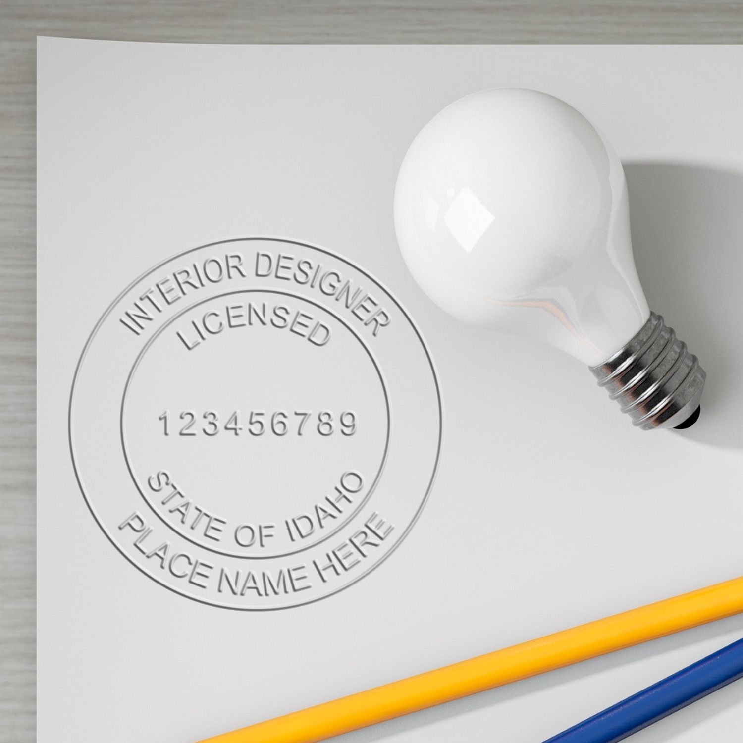 Embossed Idaho interior designer licensed seal with light bulb and colored pencils mockup.