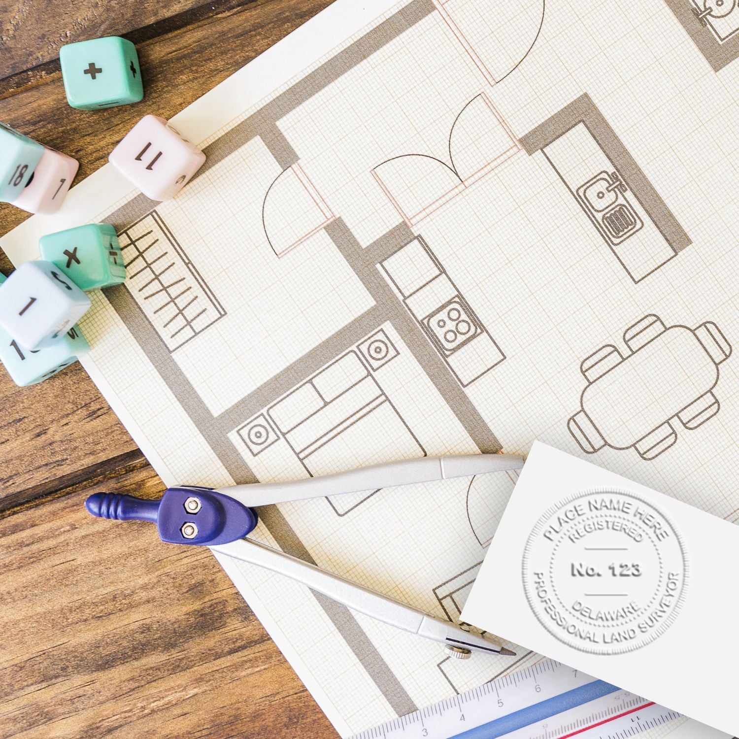 Architectural floor plan blueprint with drafting compass, ruler, and design tools on a wooden table