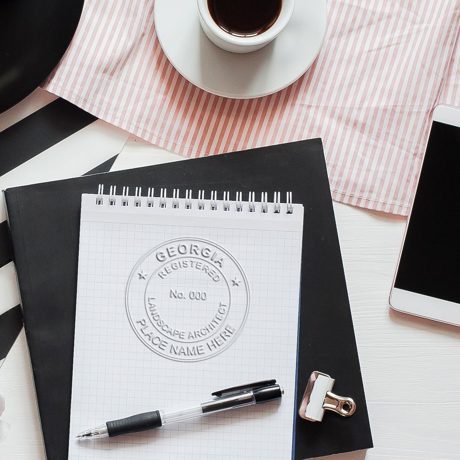 Minimalist workspace with coffee cup, notebook, pen, smartphone, and office supplies on a desk, perfect for architecture or creative planning.