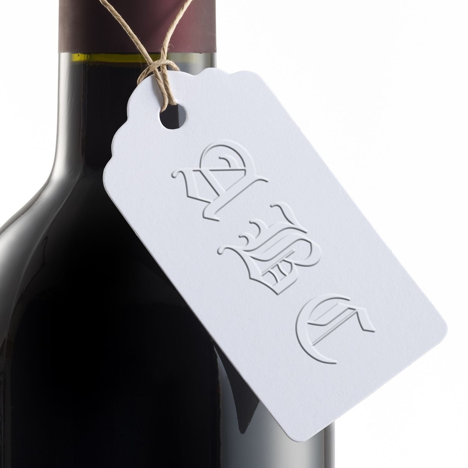 Close-up of a premium wine bottle with a blank hanging tag tied with twine on a white background.
