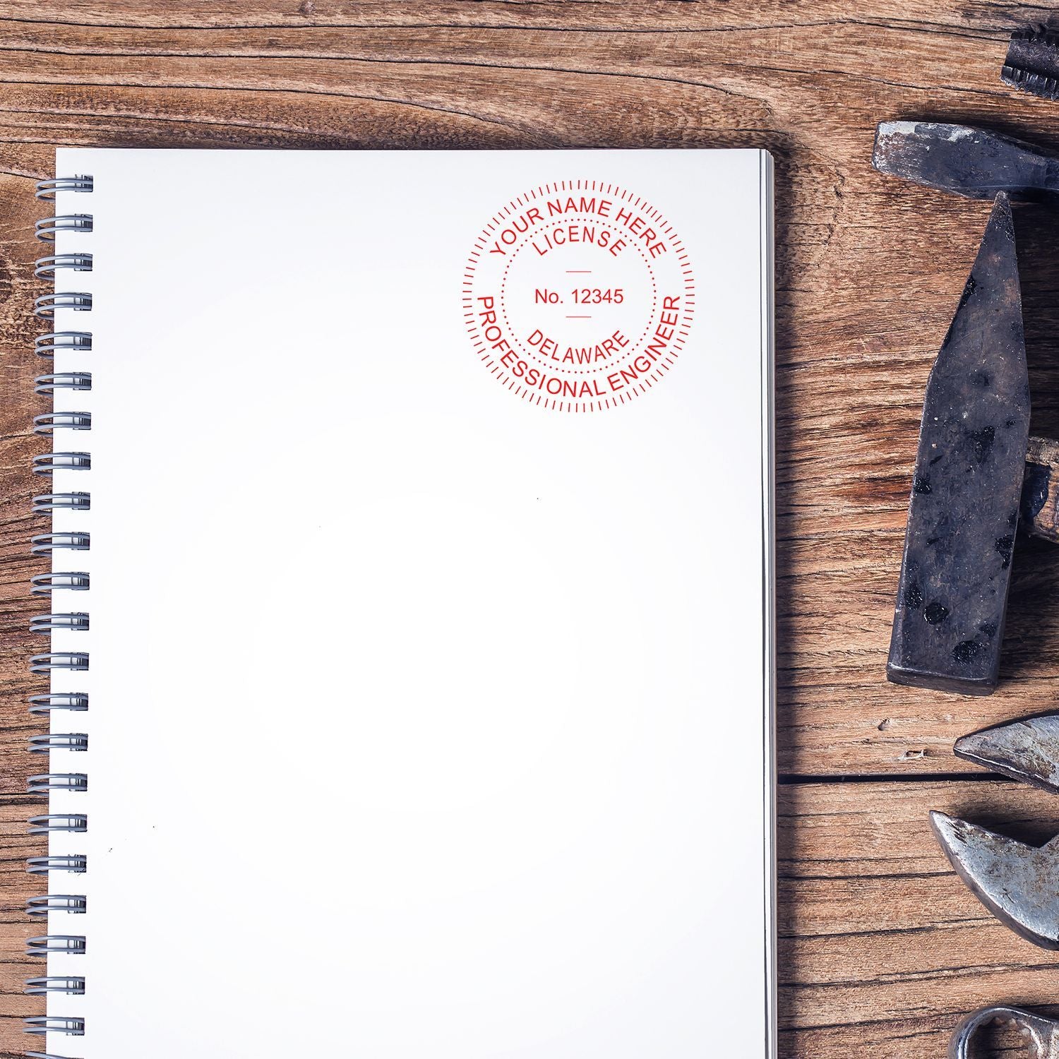 Blank spiral notebook with professional engineer license stamp on rustic wooden desk with metal tools, engineering approval concept.