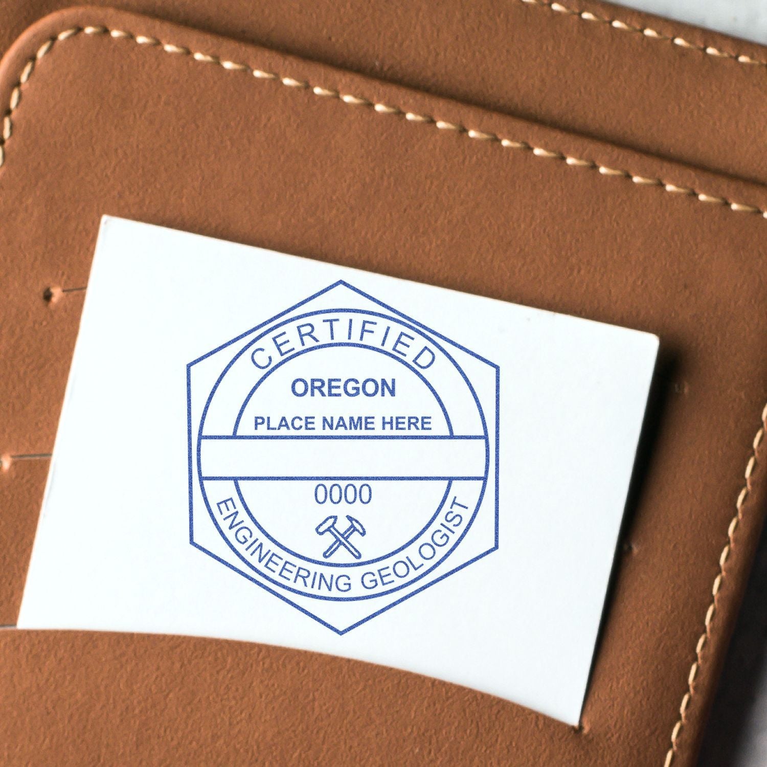 Close-up of a Certified Oregon Engineering Geologist logo sticker on a brown leather notebook cover.