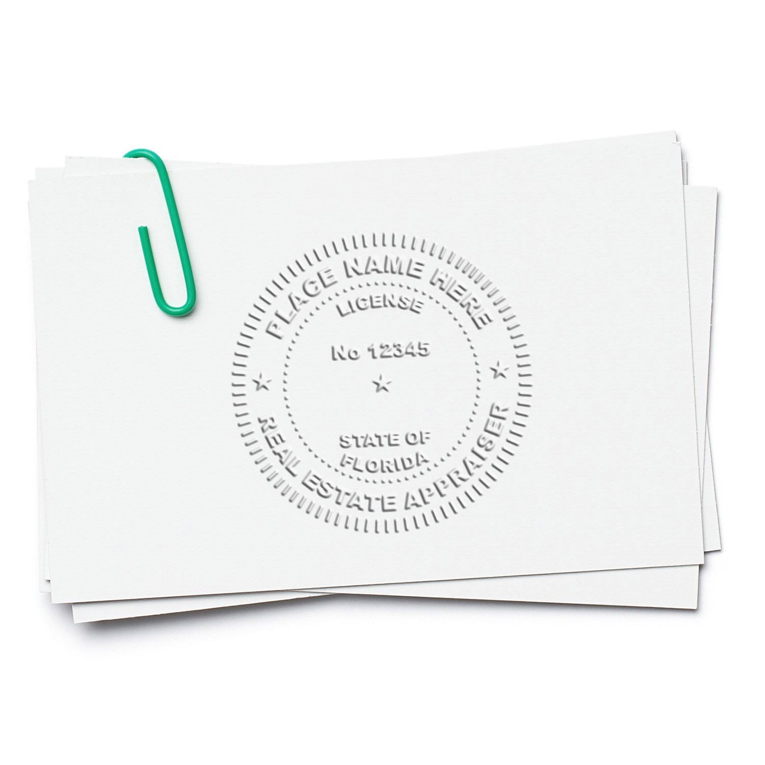 Stack of blank papers with Florida real estate appraiser license seal and green paperclip on white background