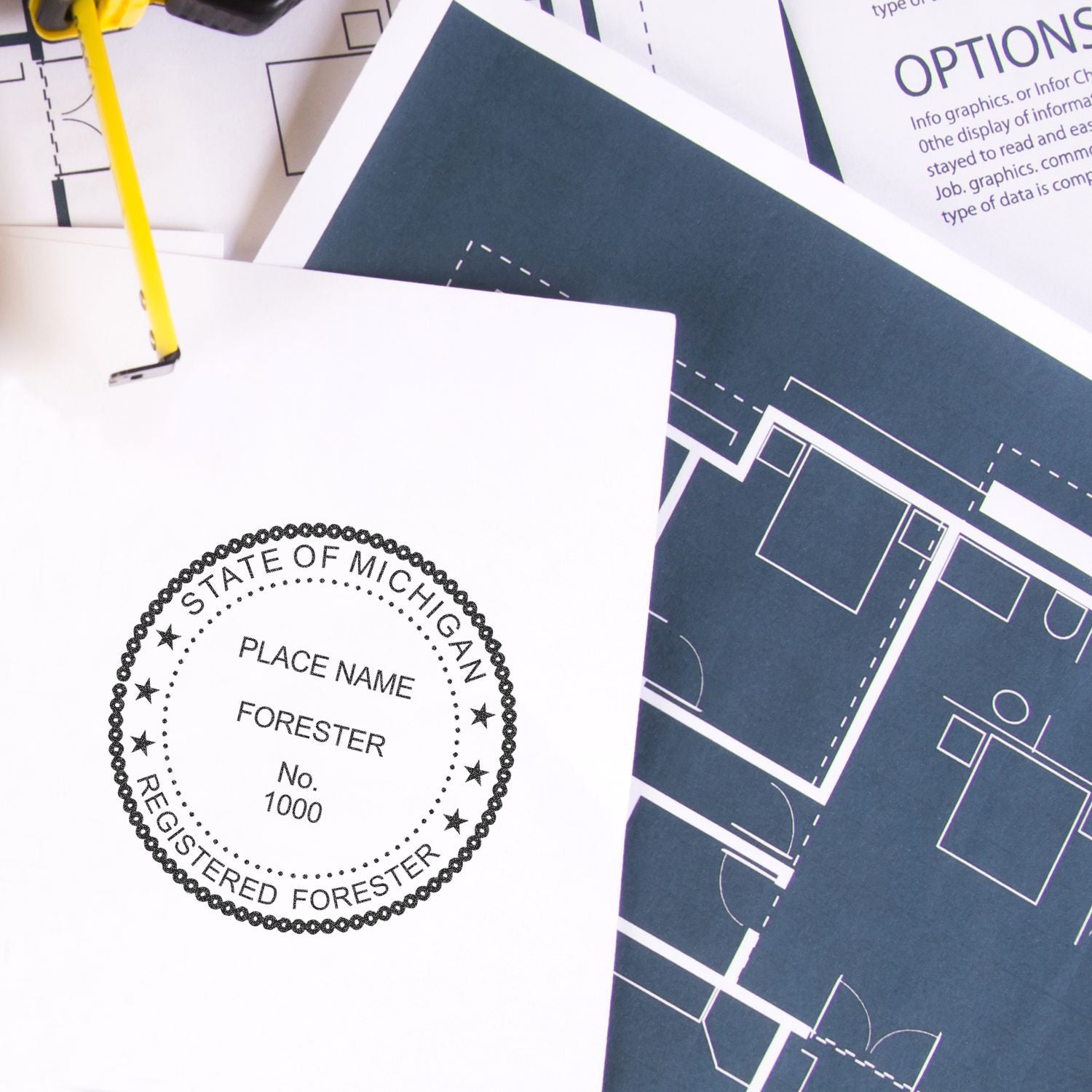 Blueprint floor plans and a State of Michigan registered forester document with pencil on top.
