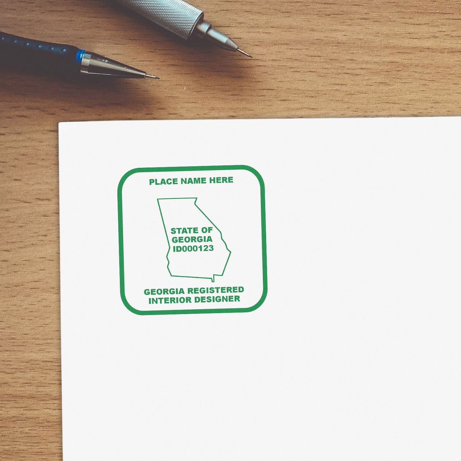 Georgia registered interior designer stamp on white paper with pens on a wooden desk