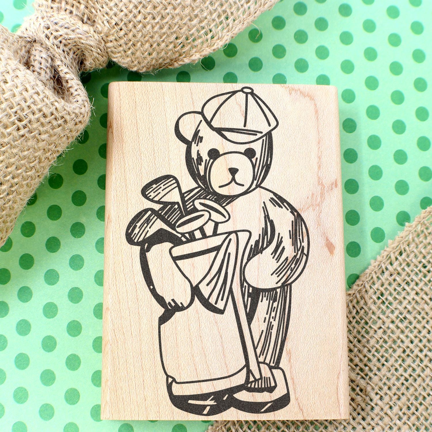 Wooden bear stamp with golf clubs on green polka dot background and burlap fabric accents