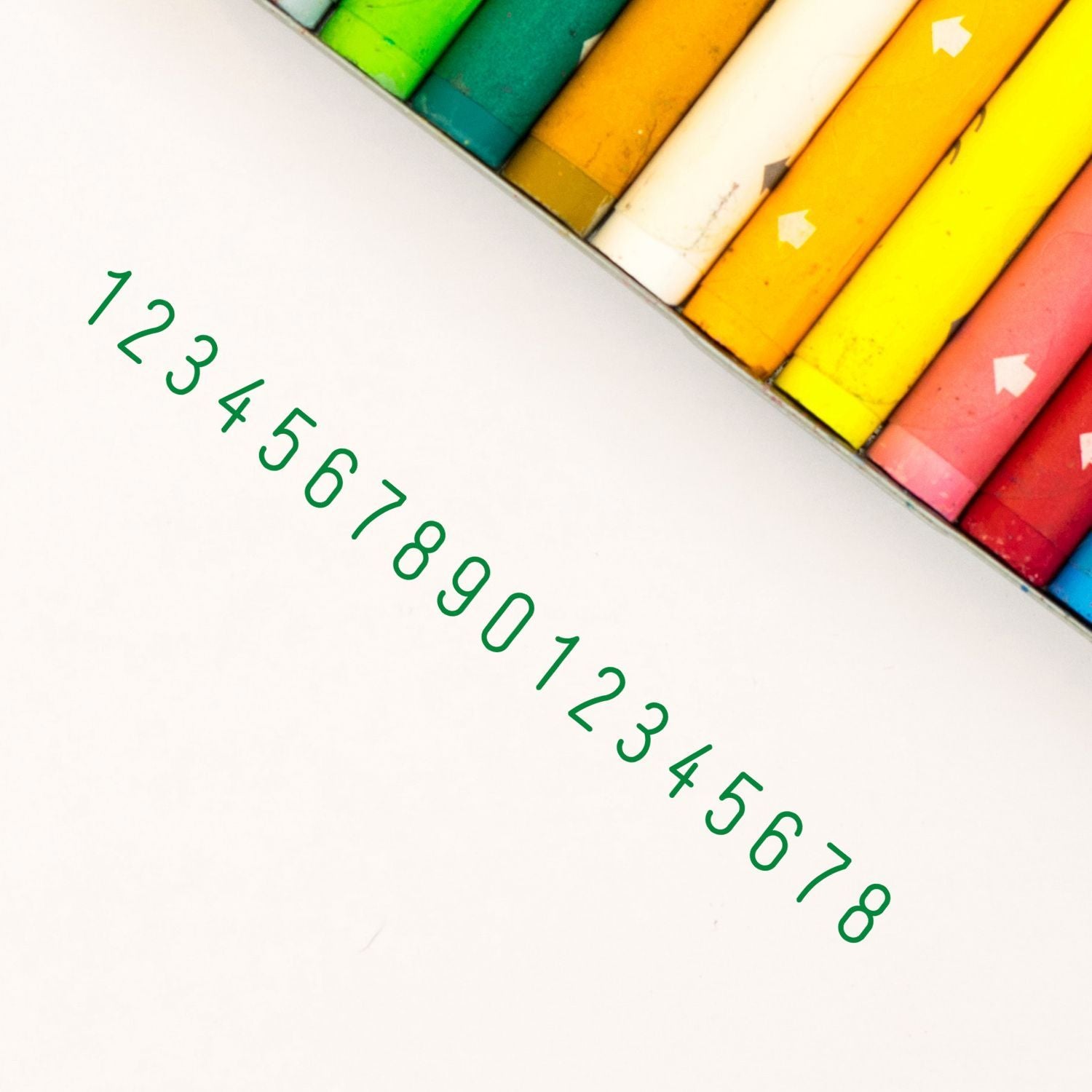 Colorful crayon tips with green handwritten numbers for kids learning counting and basic math education on a white background.