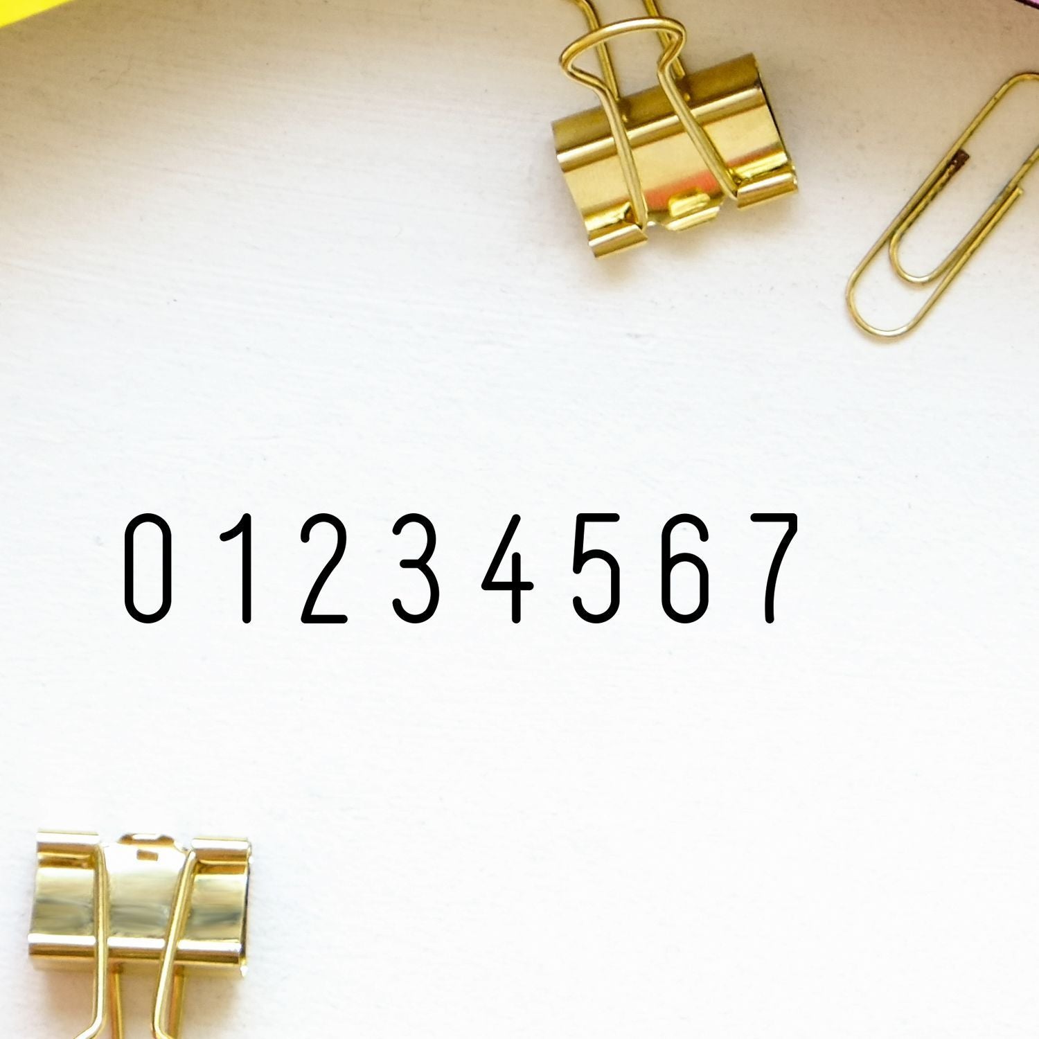 Gold binder clips on white background with large numeric label 01234567 for stationery product identification.