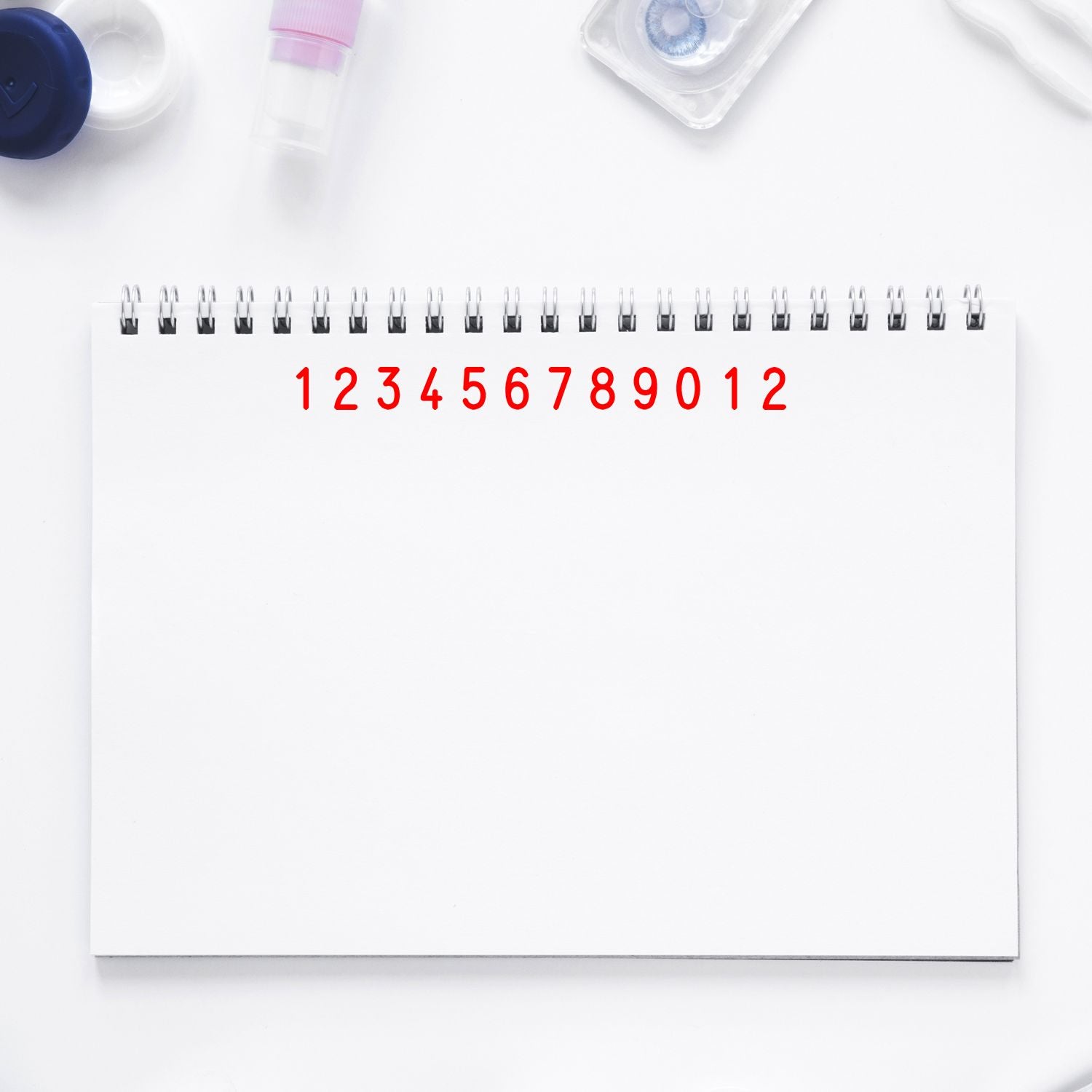 Monthly medication schedule calendar with red numbers 112 and healthcare supplies on a white desk for daily appointment tracking