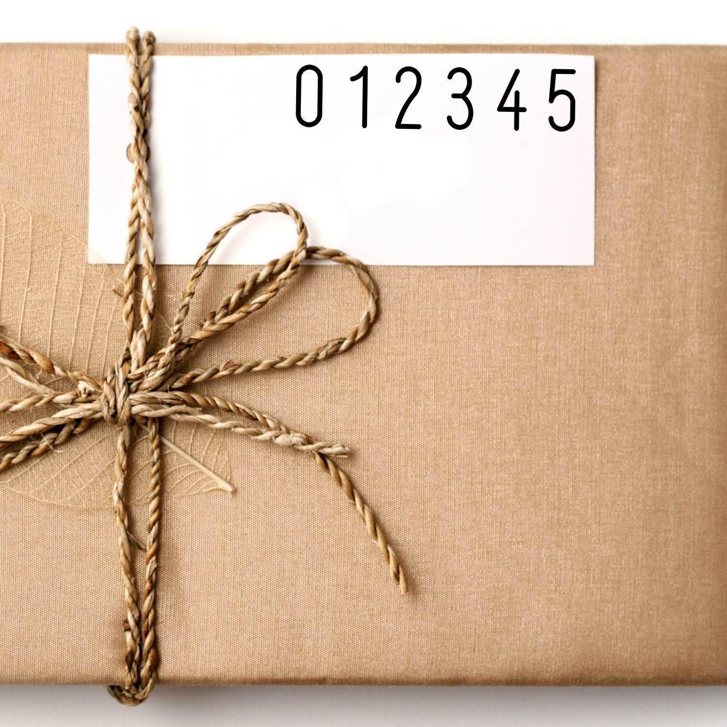 Burlap gift bundle tied with twine, featuring a label tag showing 012345 for inventory or product numbering.