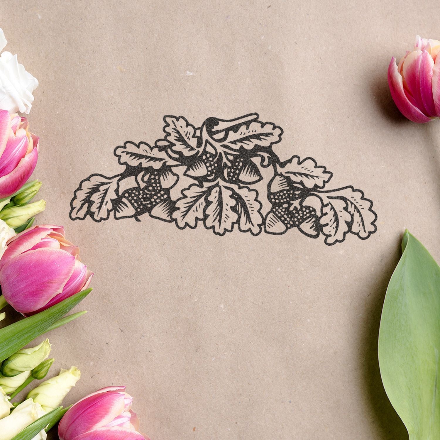 Botanical strawberry illustration on kraft paper surrounded by pink tulips and fresh green leaves.