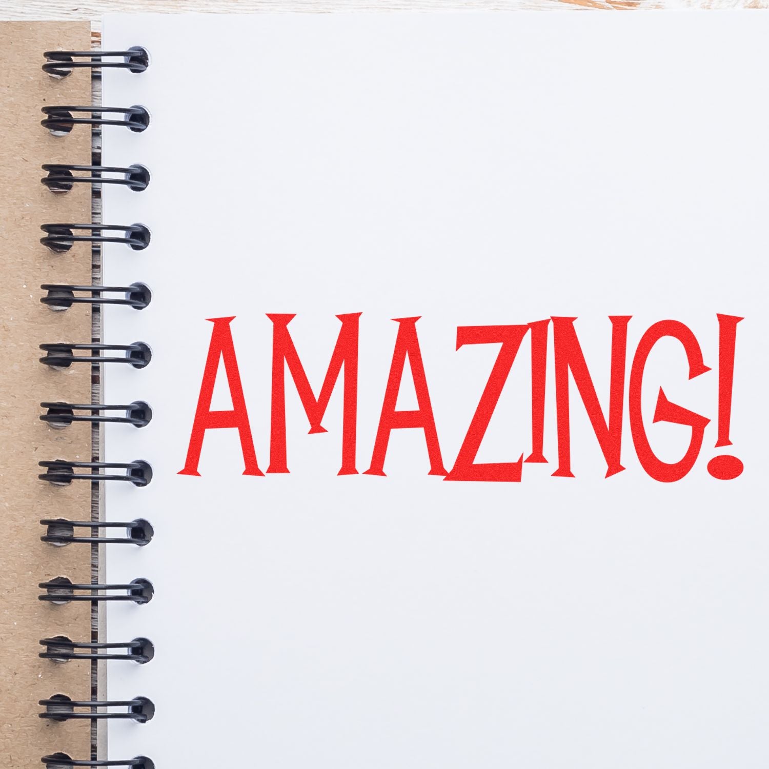Close-up of open notebook cover with binder rings and bold red AMAZING! text, inspirational slogan for planners.