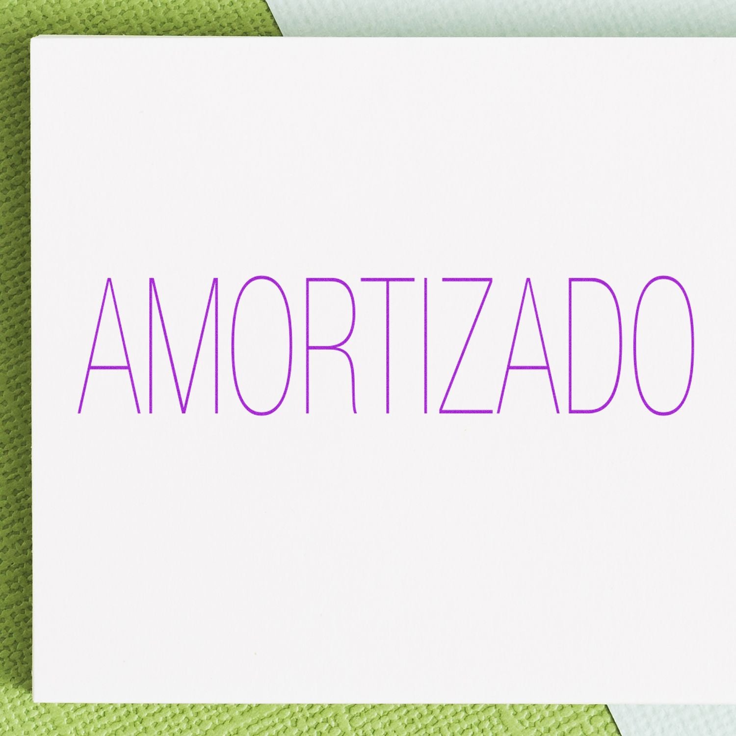 White card with the word AMORTIZADO in purple lettering on a green textured background.