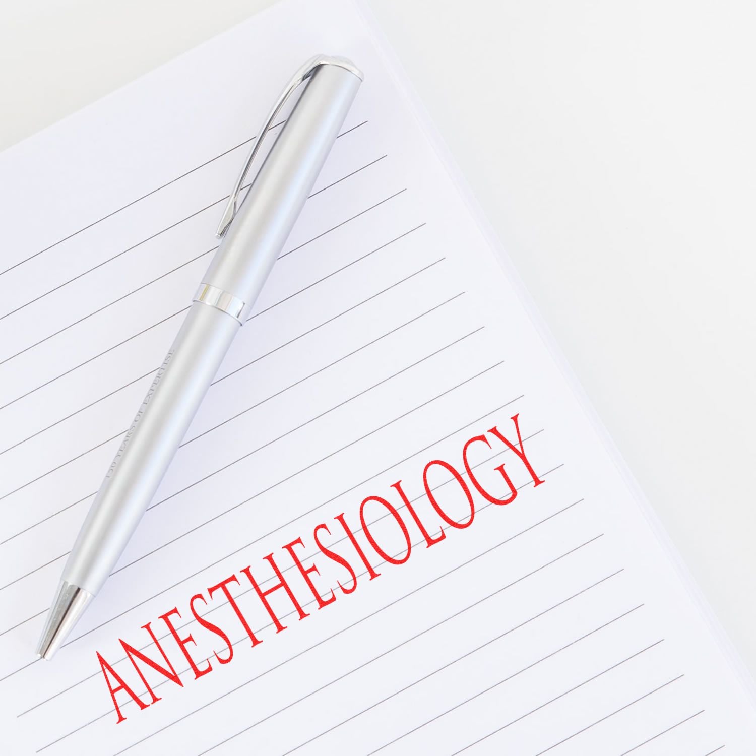 White notebook page with red Anesthesiology title and pen, illustrating anesthesiology study notes and medical documentation.