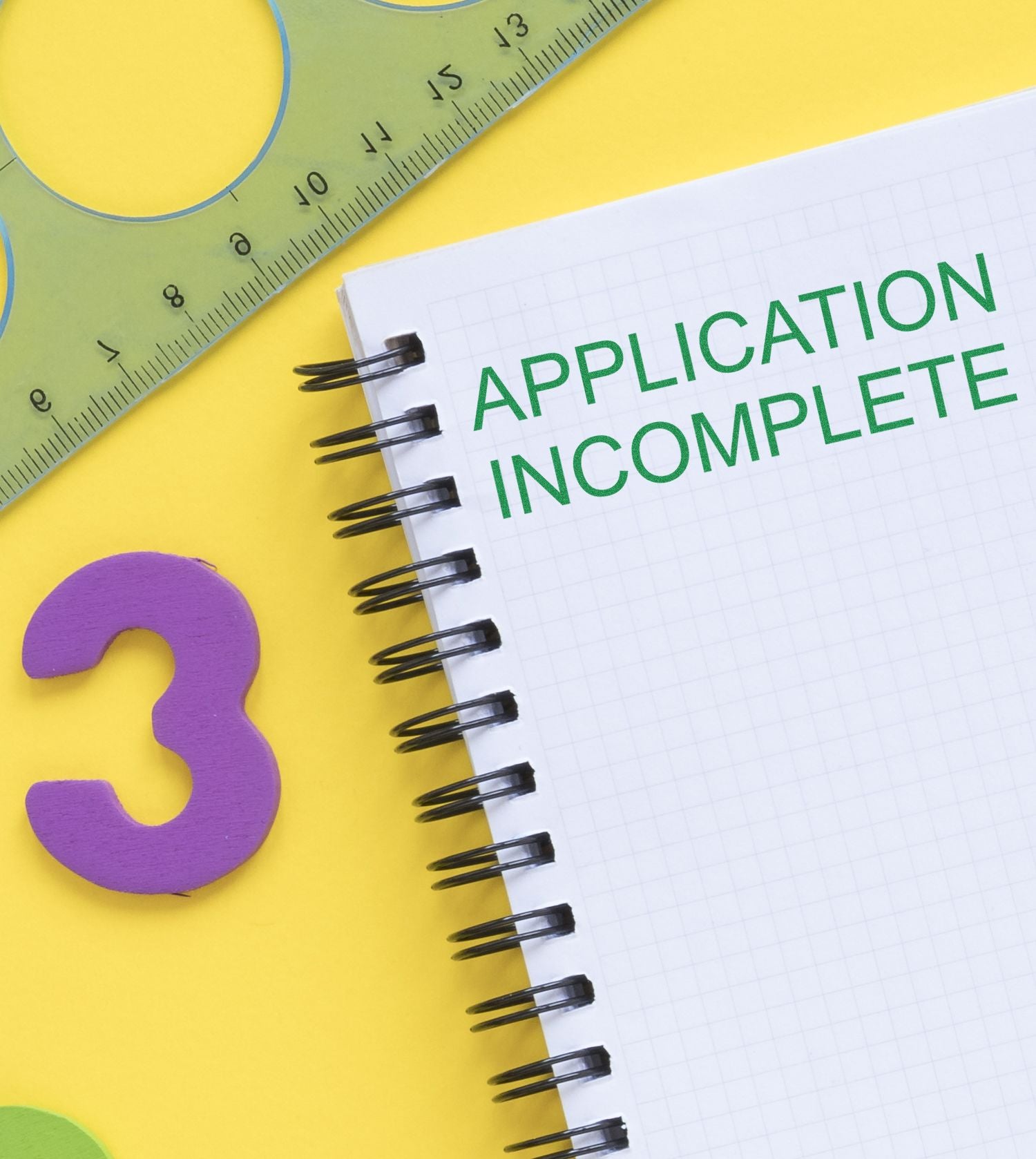 Application complete concept: notebook with green text APPLICATION COMPLETE next to ruler and question mark on yellow background