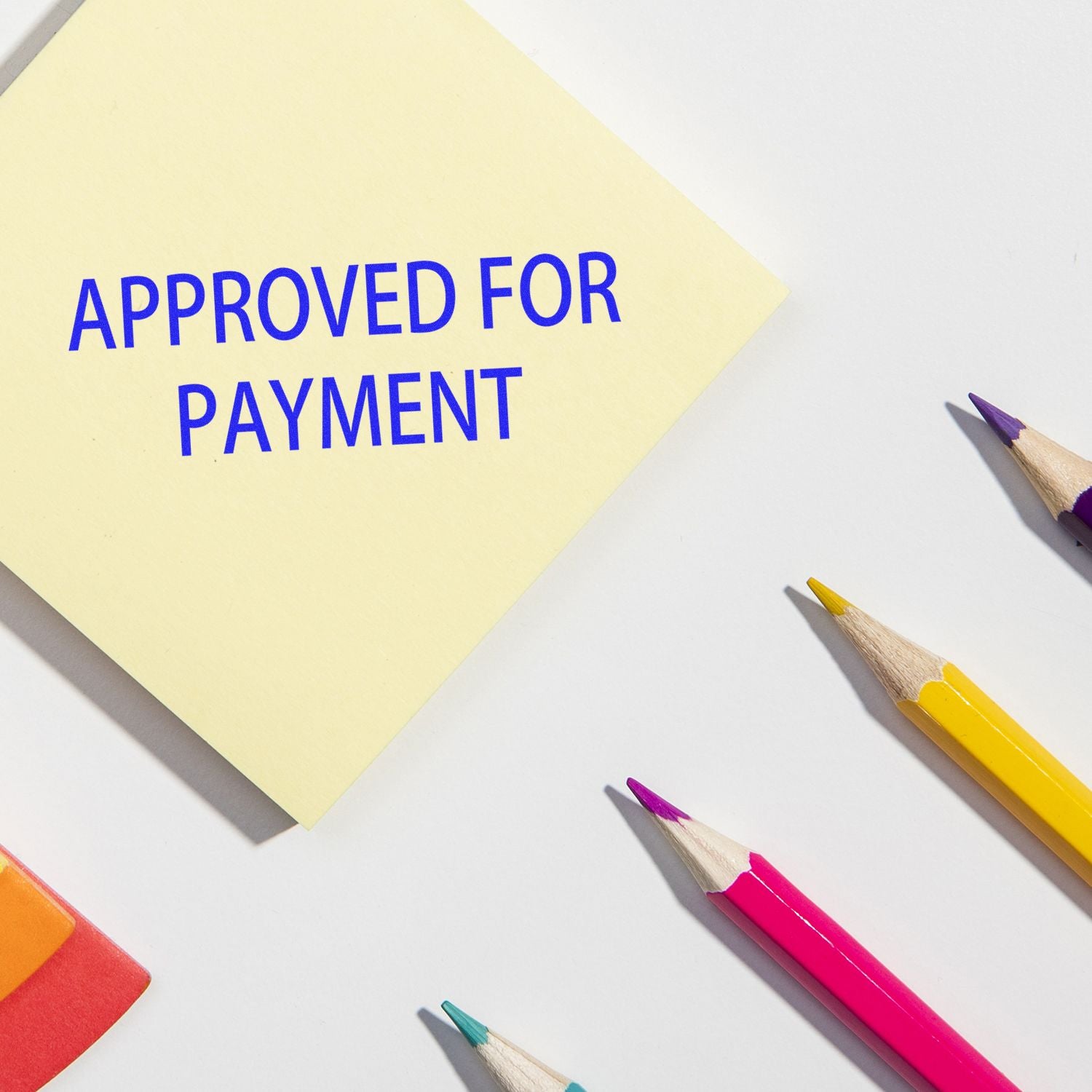 Approved for payment sticky note with pencils, indicating invoice approval for accounts payable and billing processing