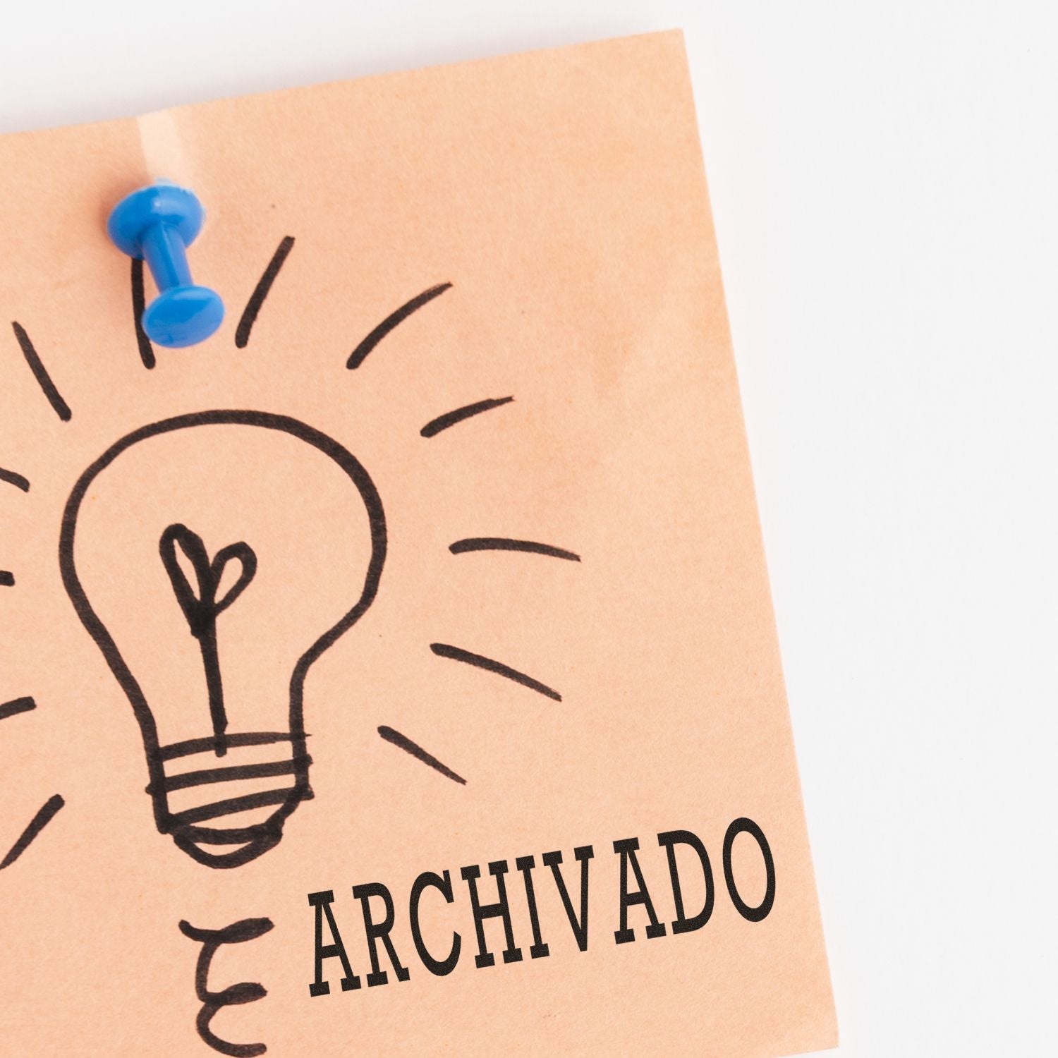 Archived idea note with hand-drawn light bulb and blue pushpin on paper.