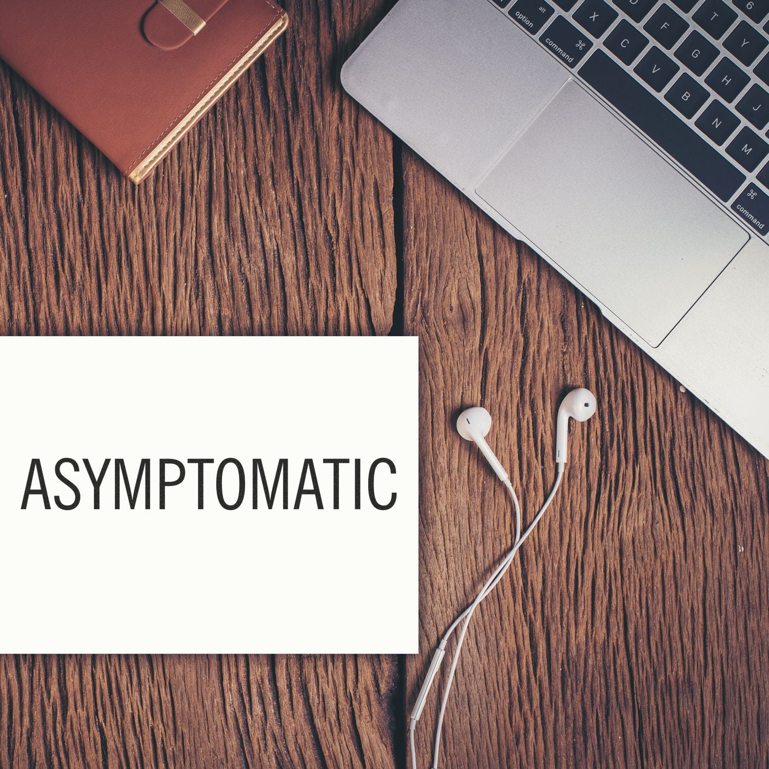Asymptomatic health awareness graphic with laptop keyboard and earphones on wooden desk, featuring ASYMPTOMATIC medical text content.