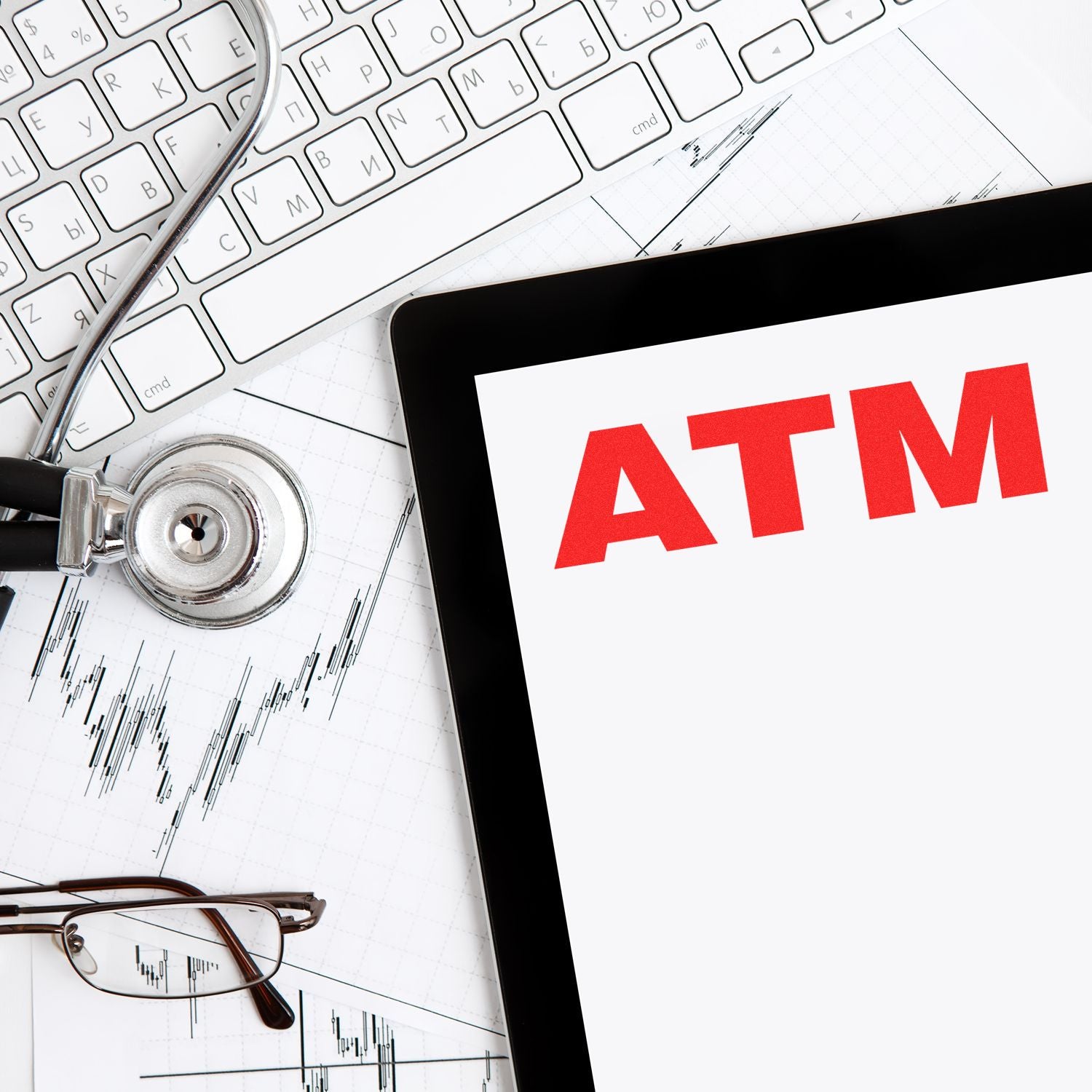 Medical data analytics concept with stethoscope, stock chart, and ATM display for healthcare finance monitoring and reporting.