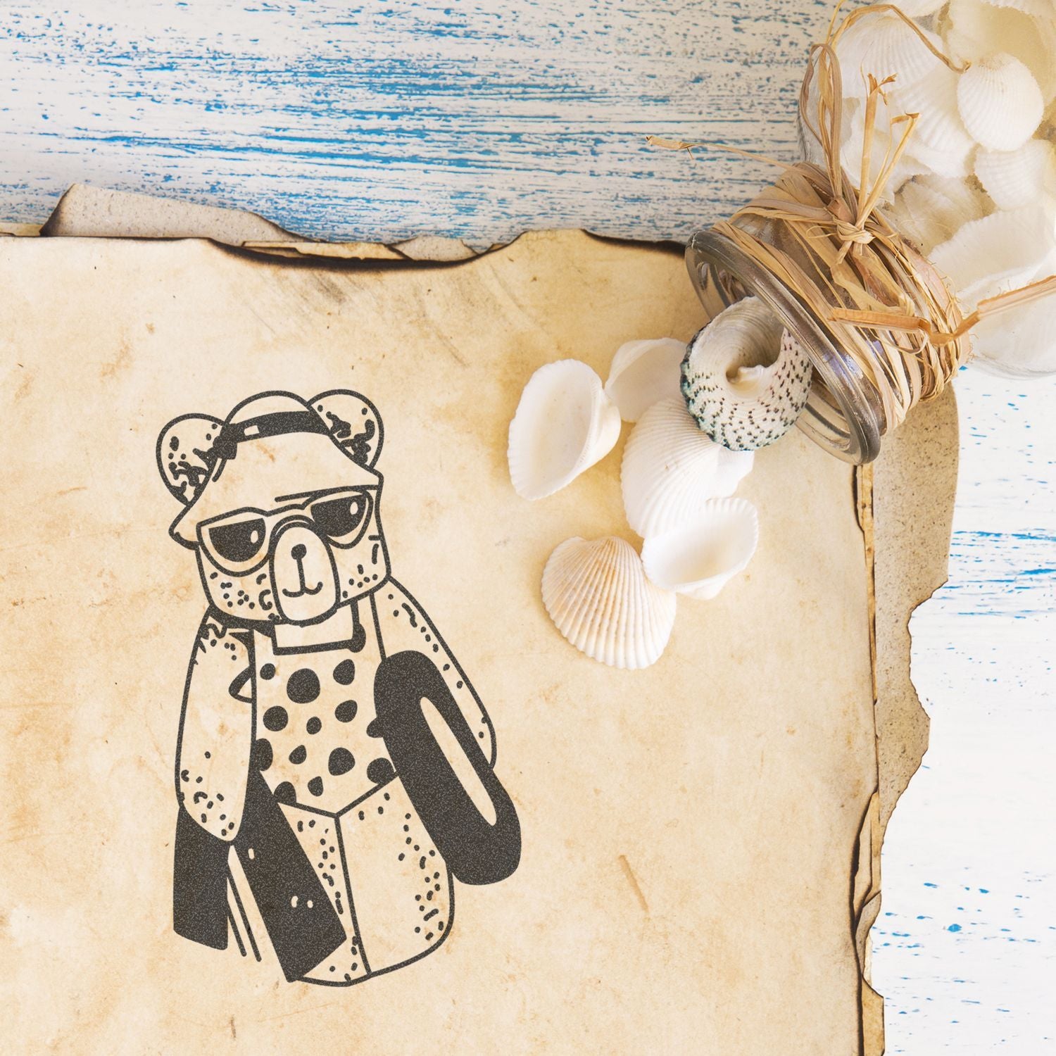 Vintage beach-themed bear illustration with sunglasses, seashells, and rustic distressed paper background.