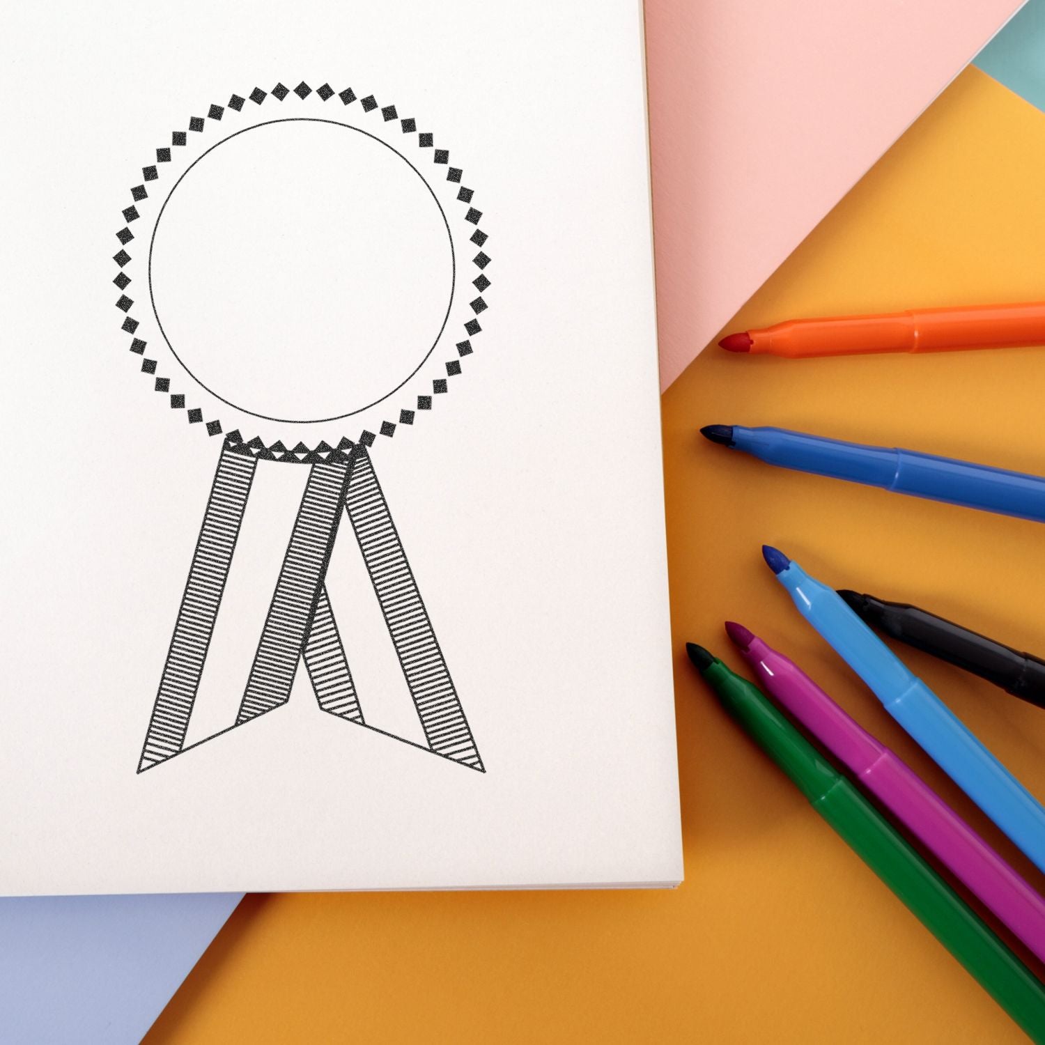 Blank award ribbon template on white paper with colorful markers on pastel background, ideal for certificate or design mockup.