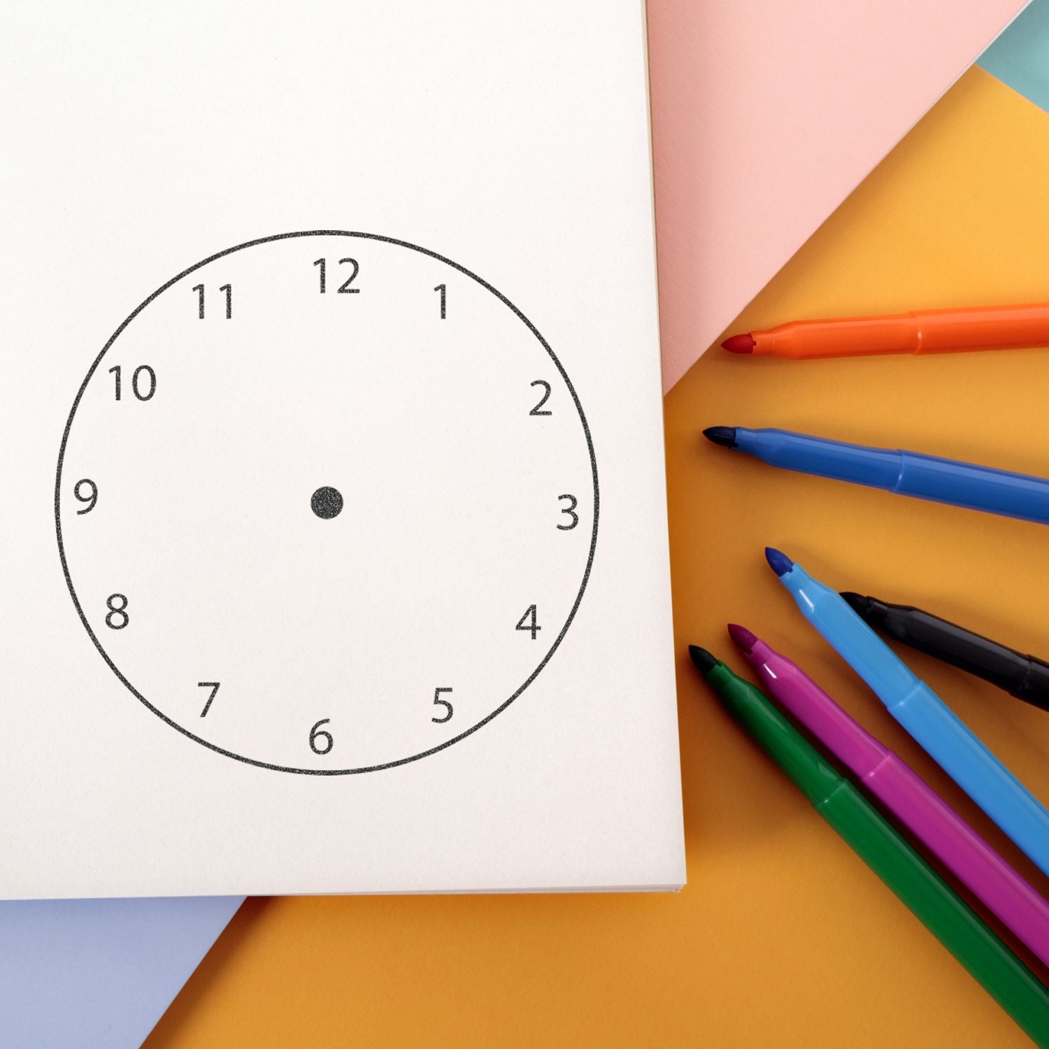 Blank clock face template with colorful markers on pastel paper, educational time-telling worksheet for kids.