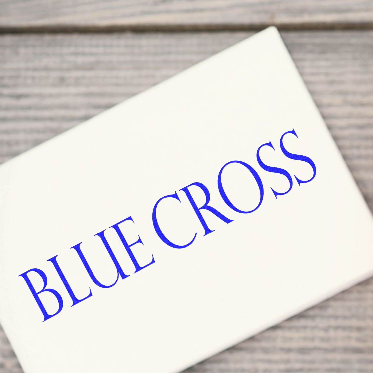 Blue Cross logo on a white paper card, representing health insurance coverage, benefits, and branded healthcare services for members.