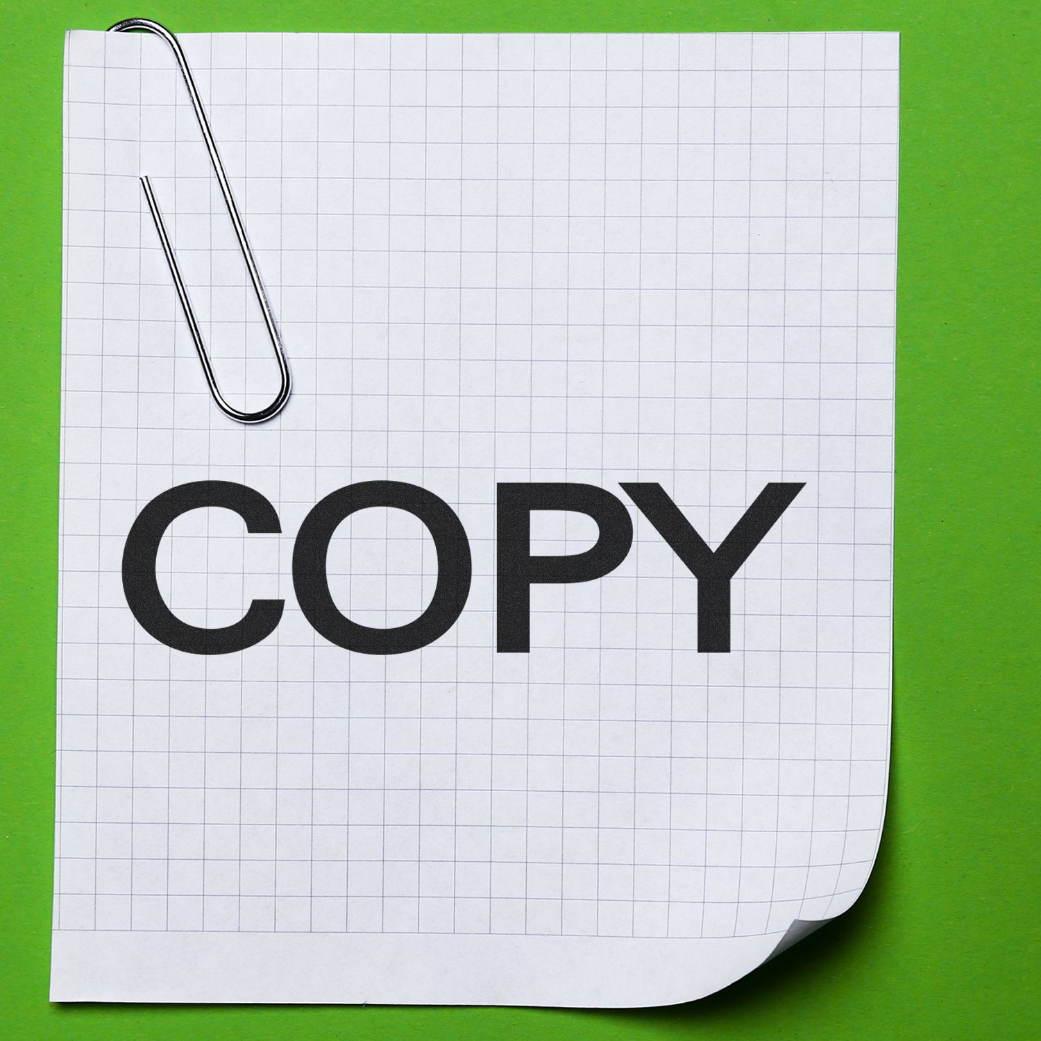 Paperclip on graph paper with the word copy, office stationery and document duplication concept