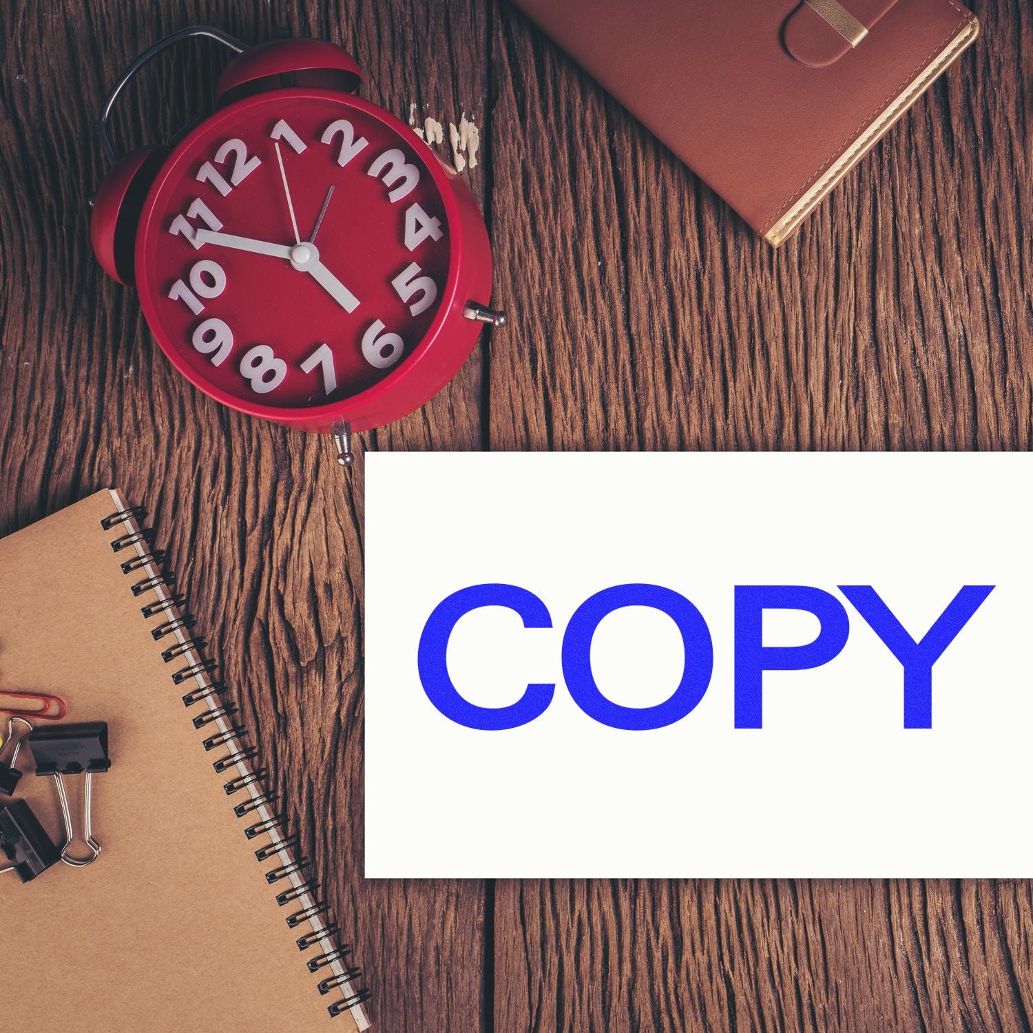 Red alarm clock and office stationery on wooden desk with COPY text, productivity and copywriting concept.