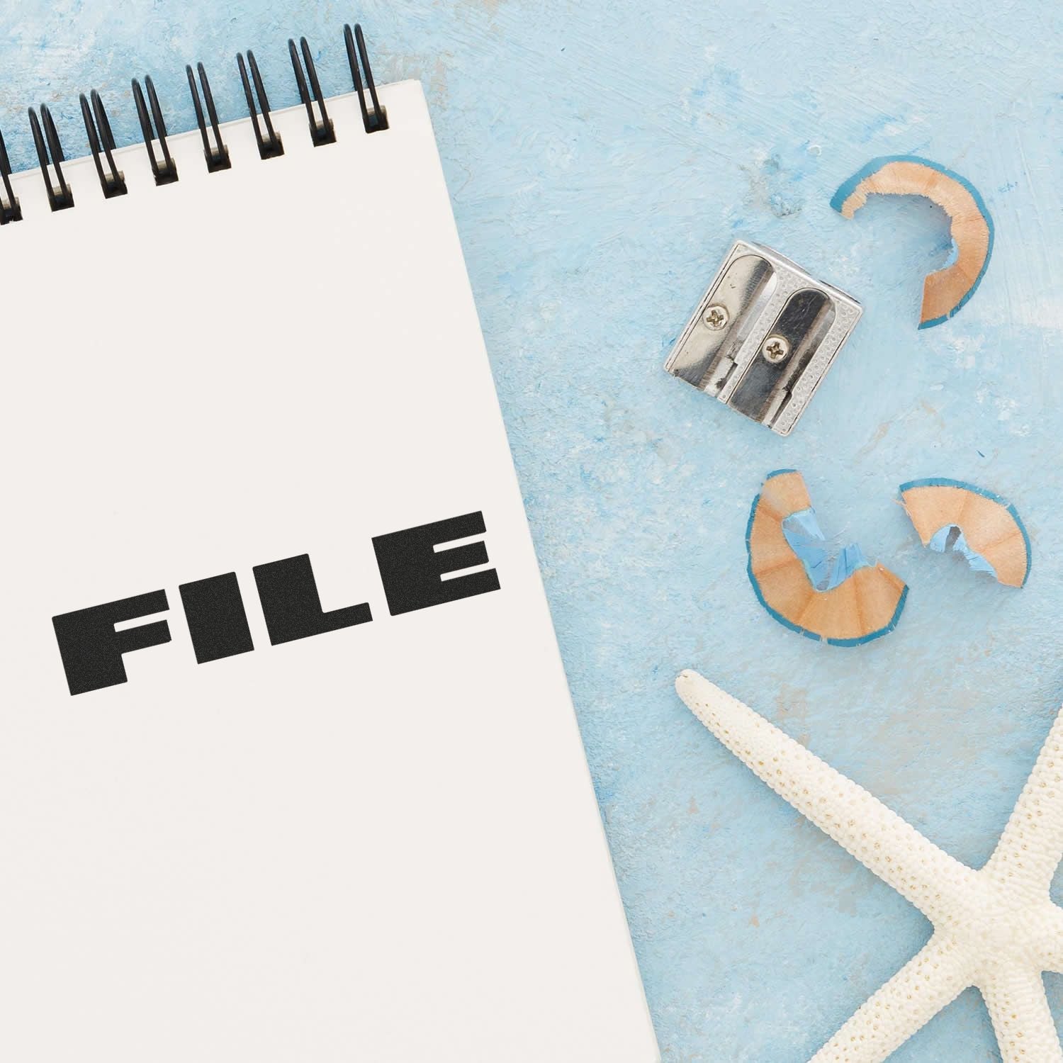 FILE label on a white document sheet with a metal clip on a blue beach background with starfish, illustrating file management.