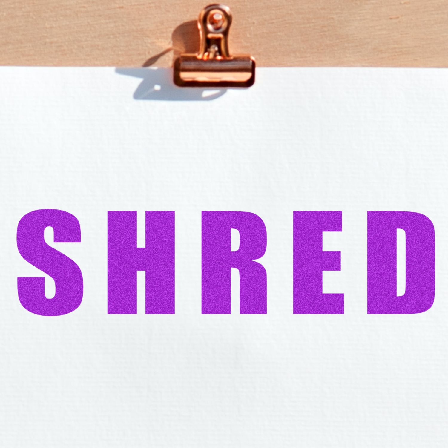 Clipboard with blank paper and bold purple SHRED text, symbolizing document shredding or secure paper disposal.