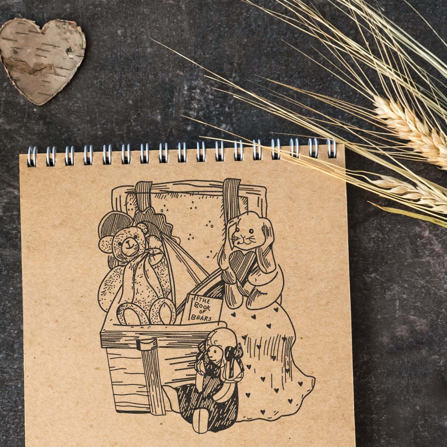 Spiral notebook with cute bear illustration and rustic kraft paper design on a dark background with wheat decor.