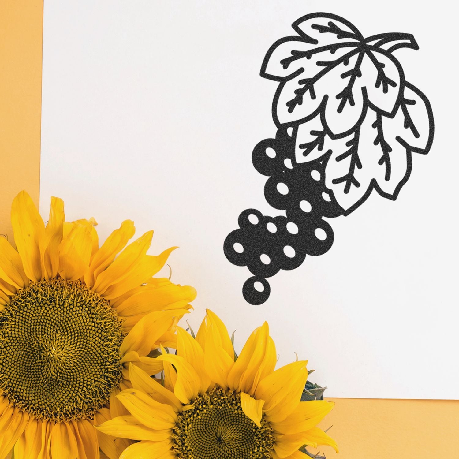 Bright sunflowers with a black grapevine leaf illustration on a white background, modern botanical design.