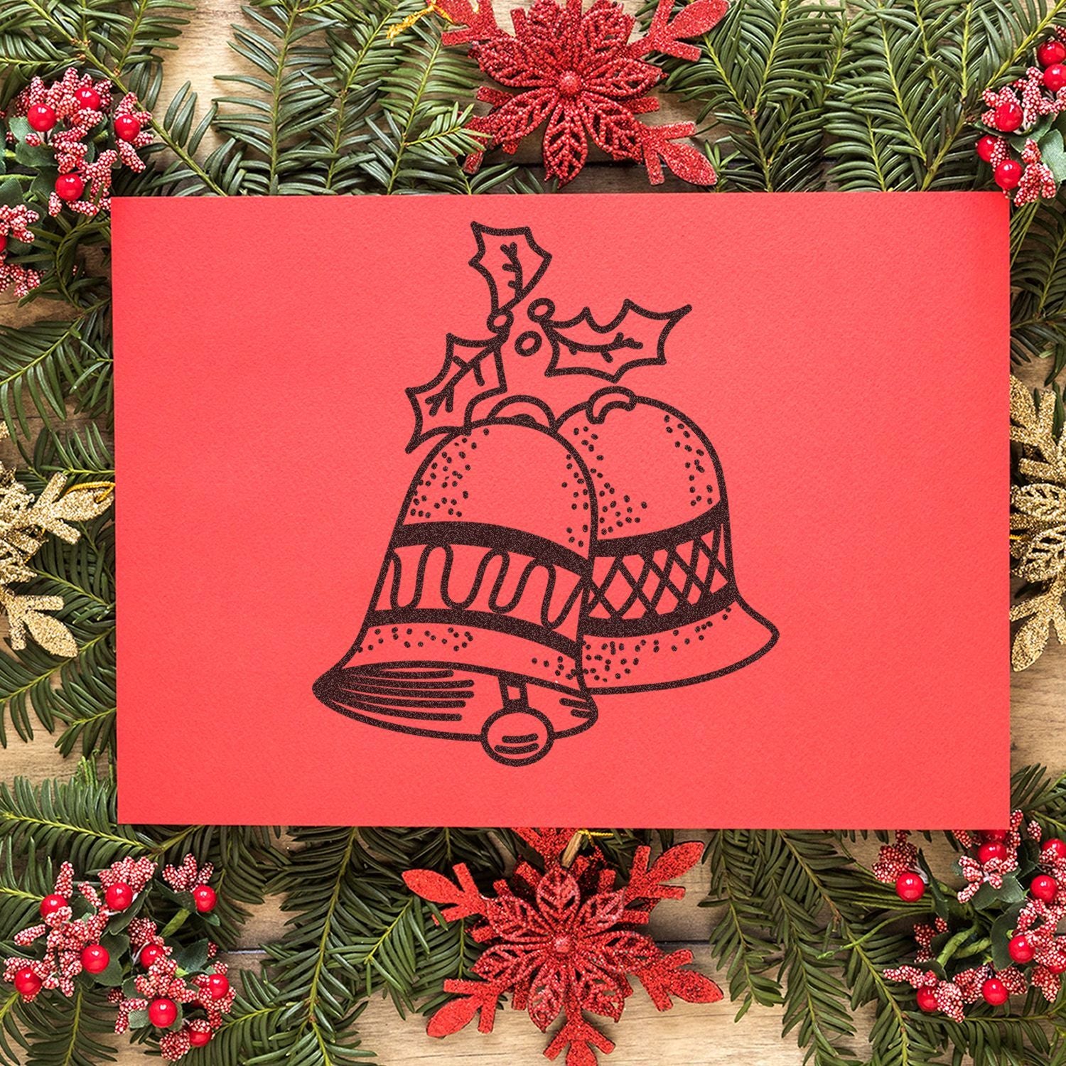 Festive red Christmas card with holly and bells, surrounded by evergreen garland and holiday decorations.