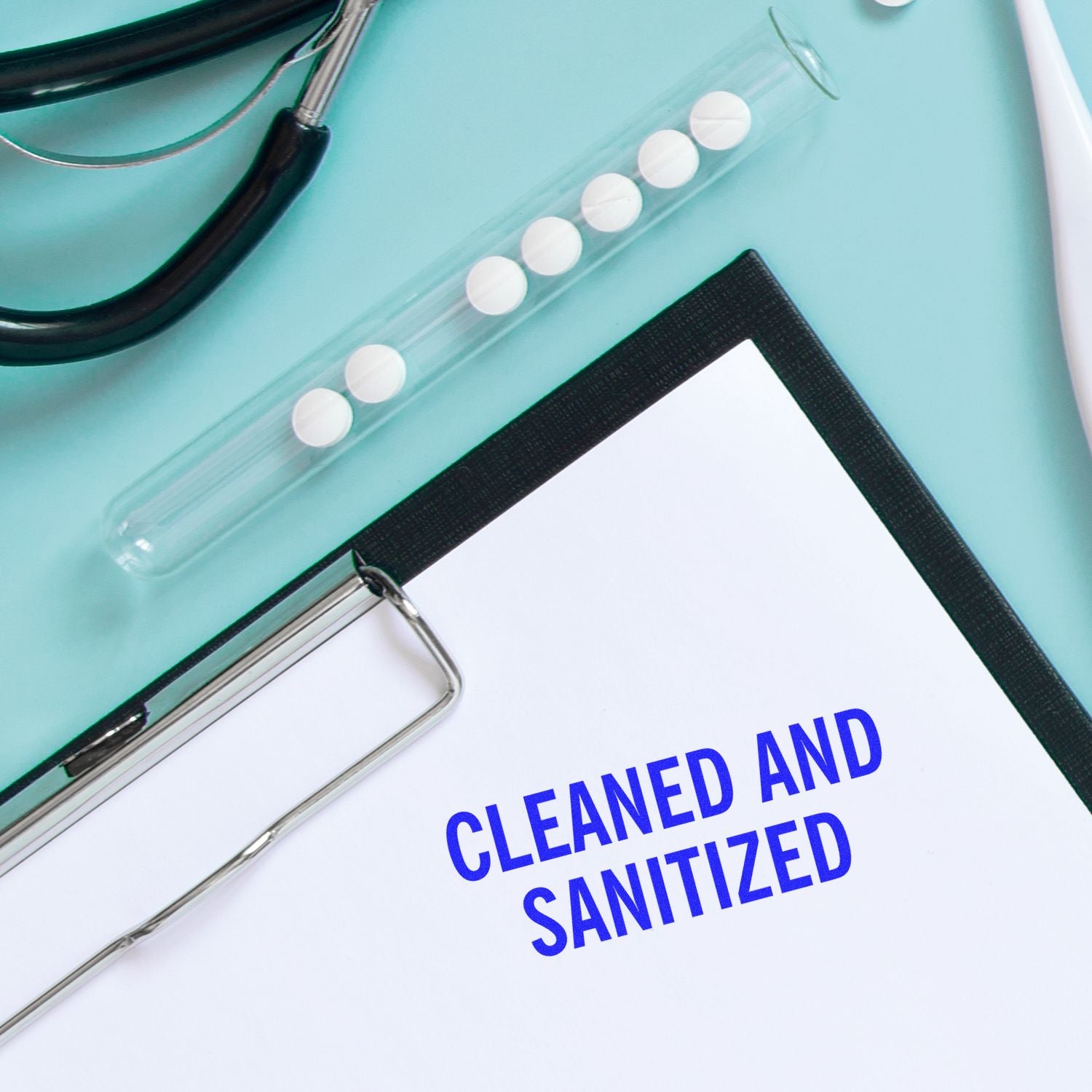 Medical clipboard labeled Cleaned and Sanitized with pills in a vial and a stethoscope on a blue background.