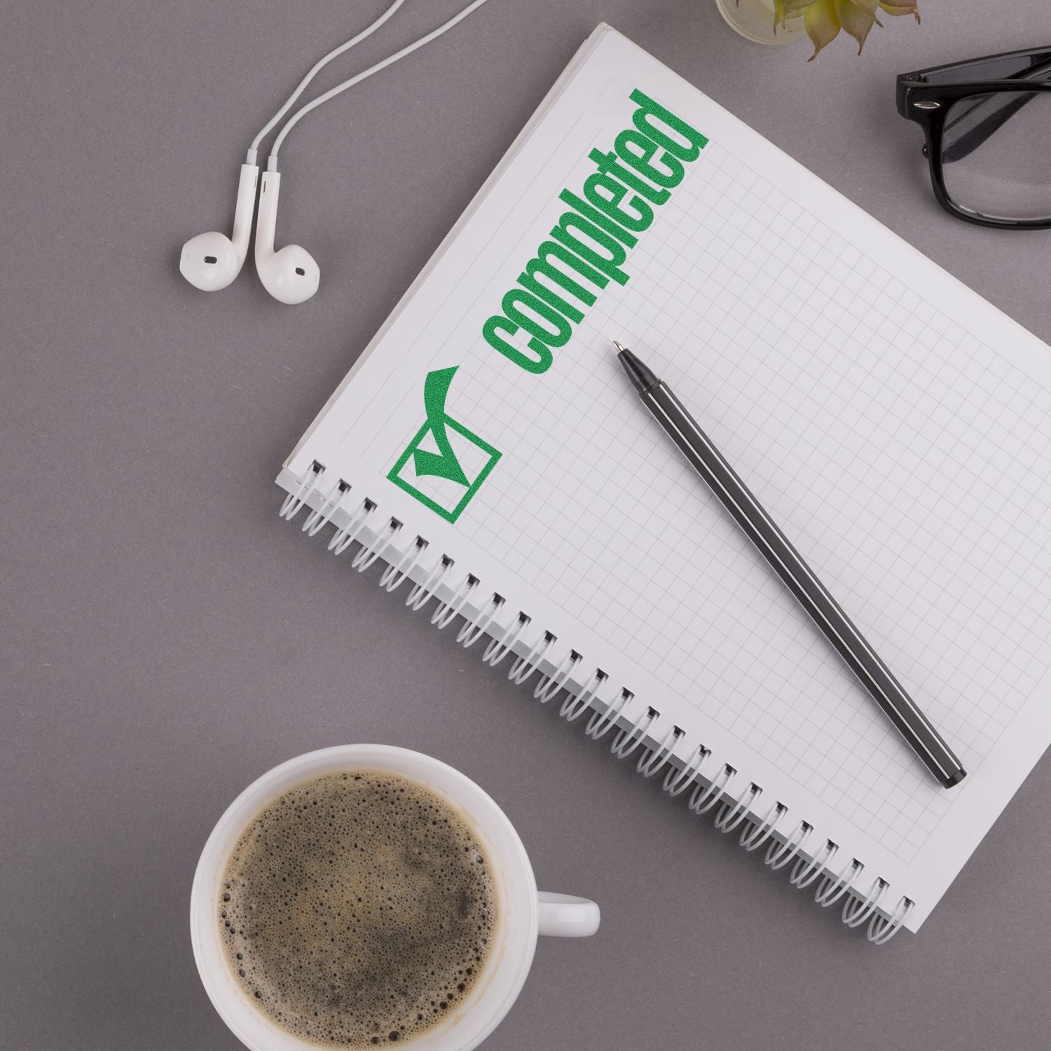 Notebook page showing communication with a green recycle icon, with pen, headphones, and coffee for eco-friendly messaging ideas.
