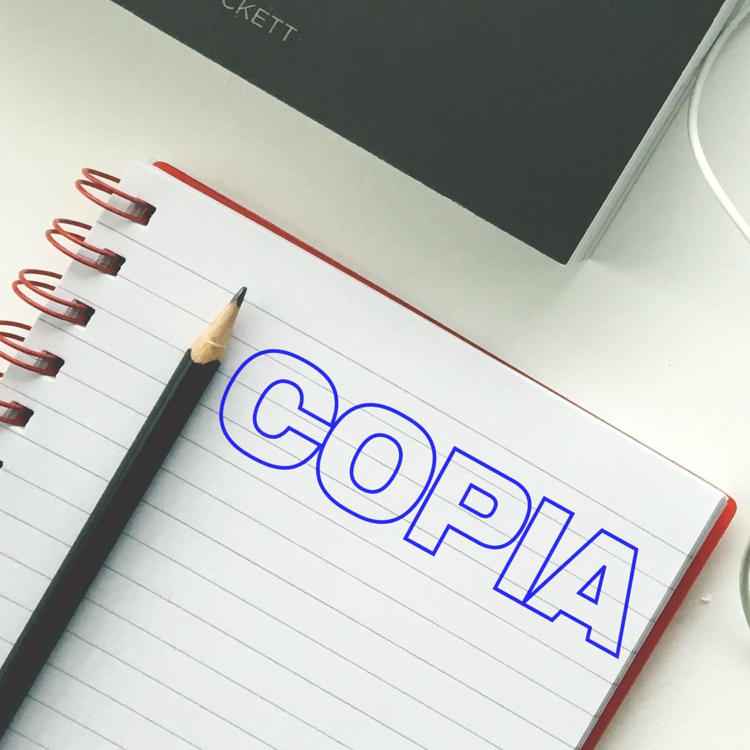 Open notebook with pencil and COPIA text, representing copywriting and office stationery.