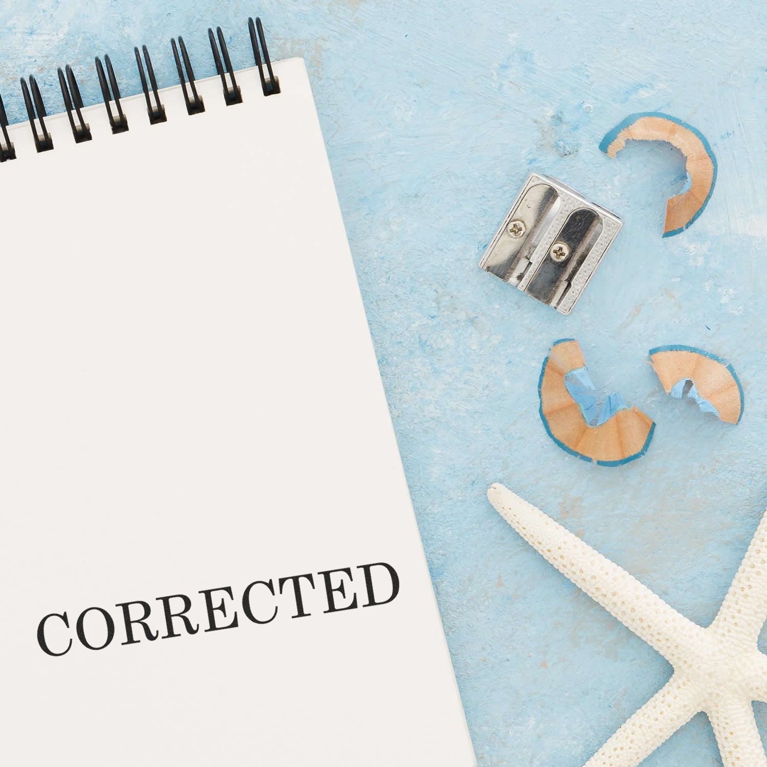 Ocean-themed corrected notice card with pushpins, starfish, and pencil on blue background for proofreading editing service updates