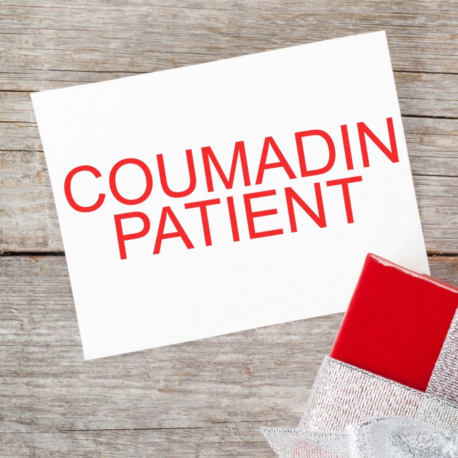 Coumadin patient card on rustic wooden background with red gift box