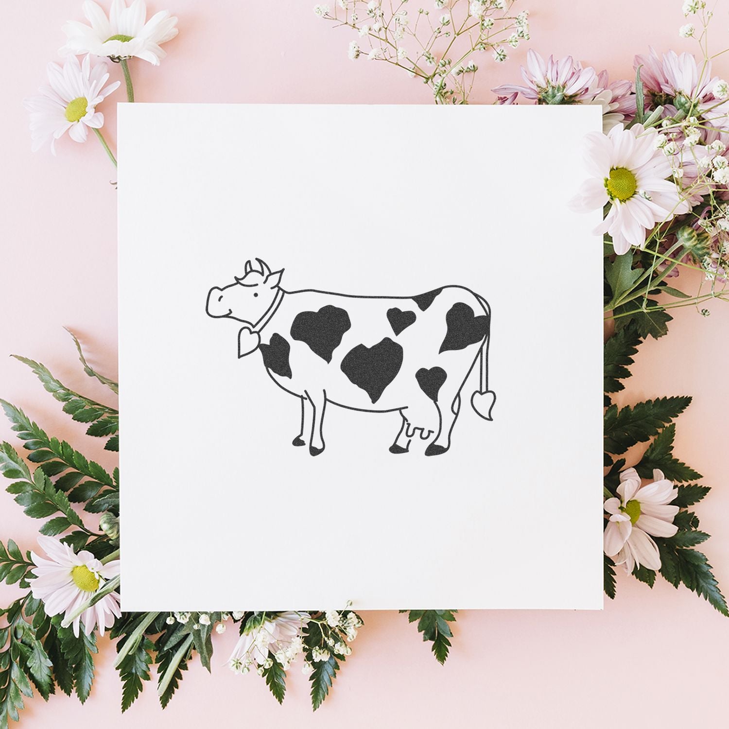 Minimal cow illustration with heart-shaped spots on a white card, surrounded by pink daisies on a pastel floral background.
