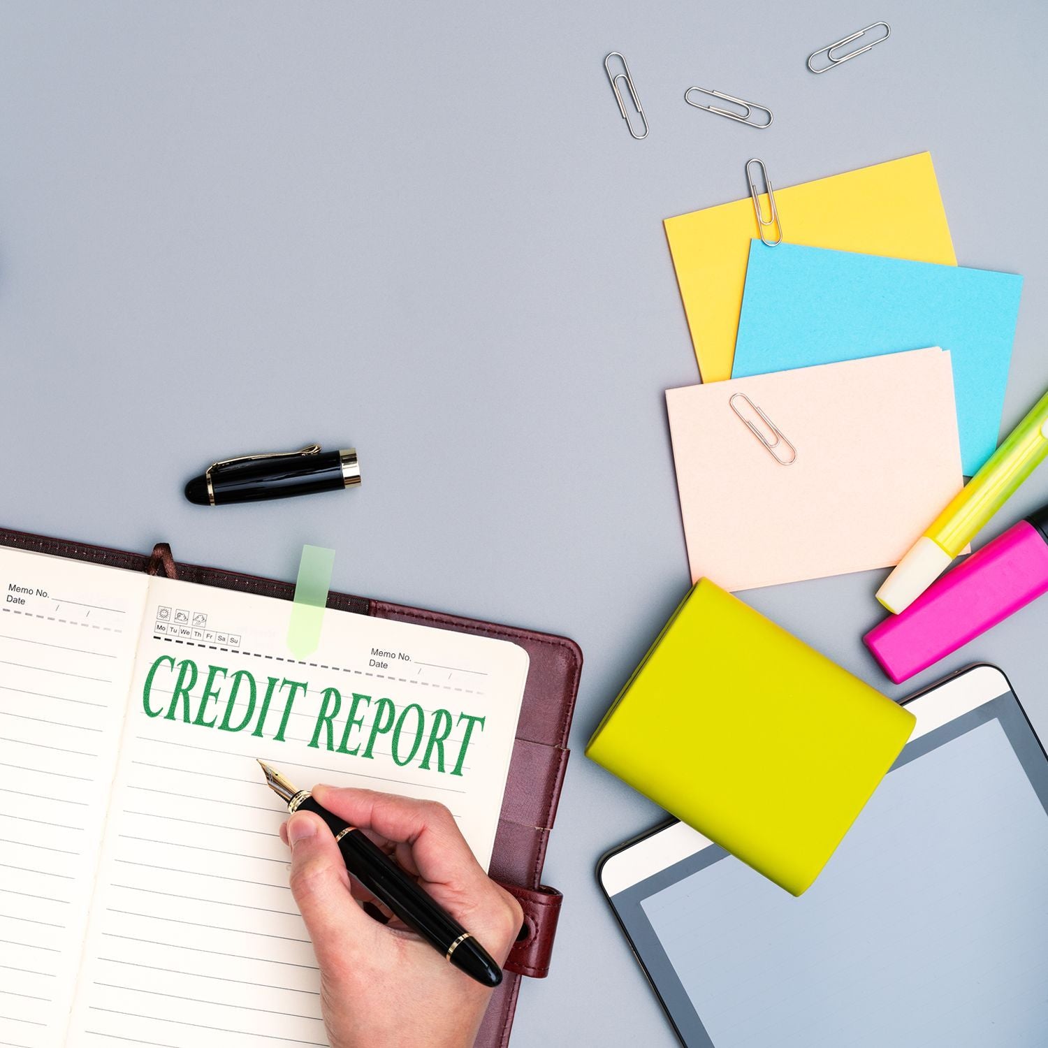 Hand writing CREDIT REPORT on planner with pens and colorful notesfinancial credit score documentation for review