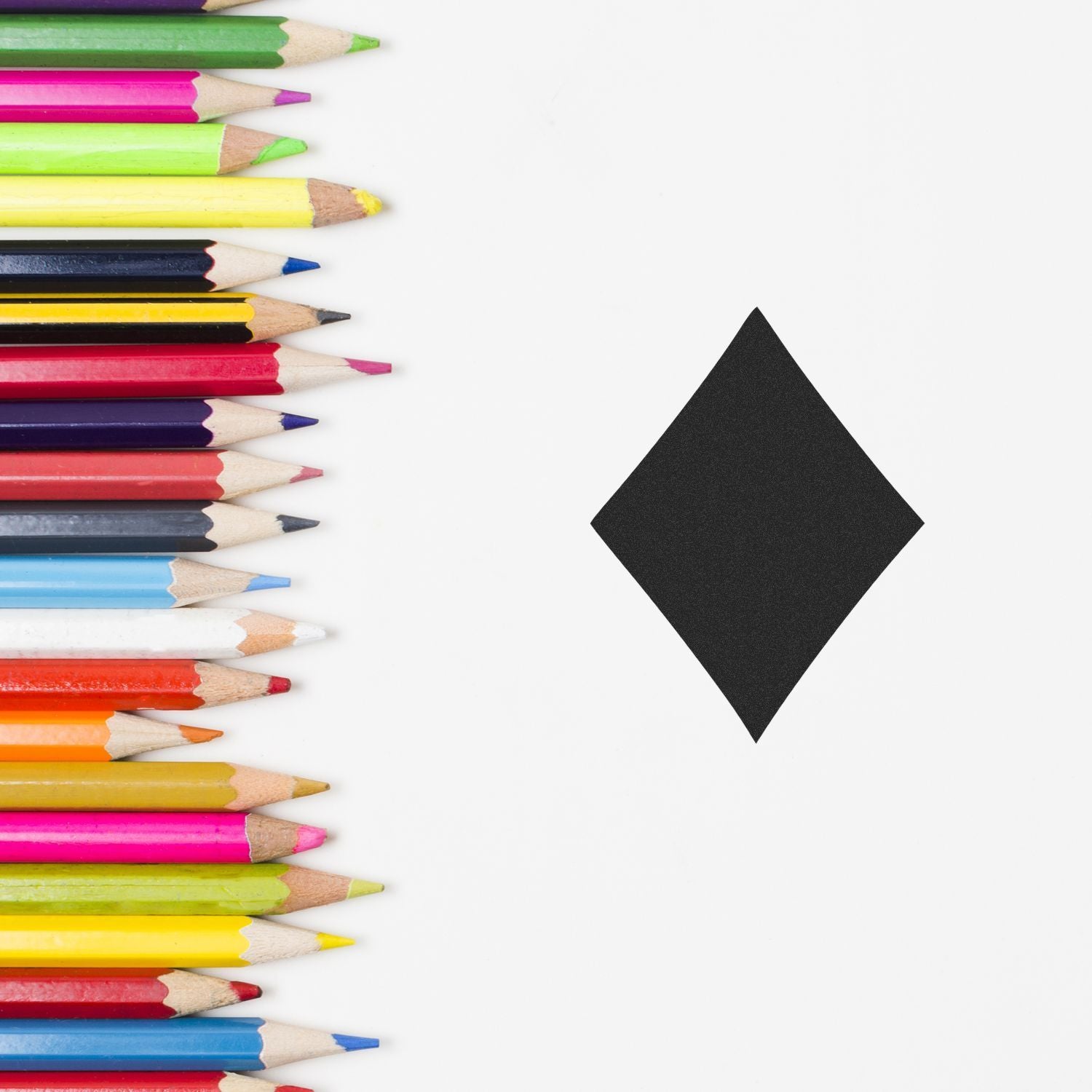 Colorful pencils lined on a white background with a black diamond shape, creative design and education concept.
