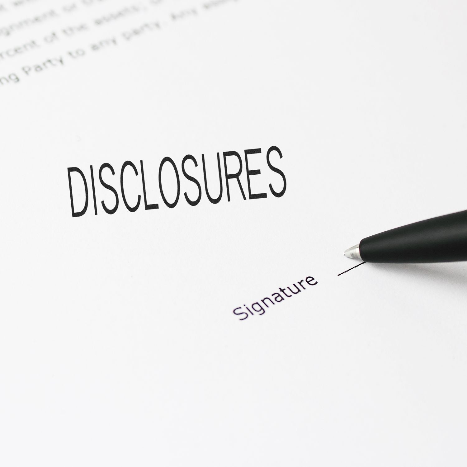 Close-up of disclosure form with signature line and pen ready to sign legal document.