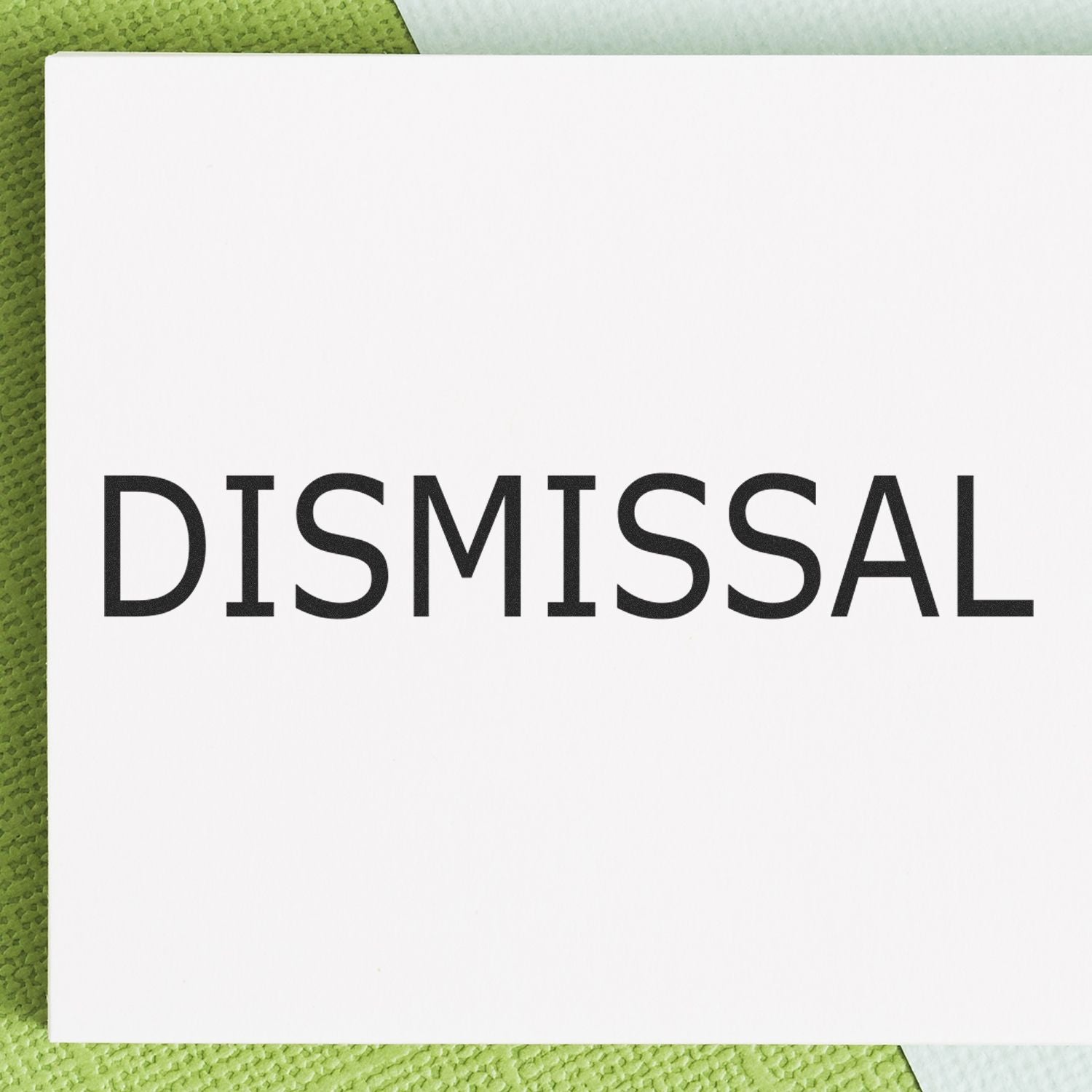 Dismissal notice card with bold word DISMISSAL on green textured background, representing employment termination documentation.
